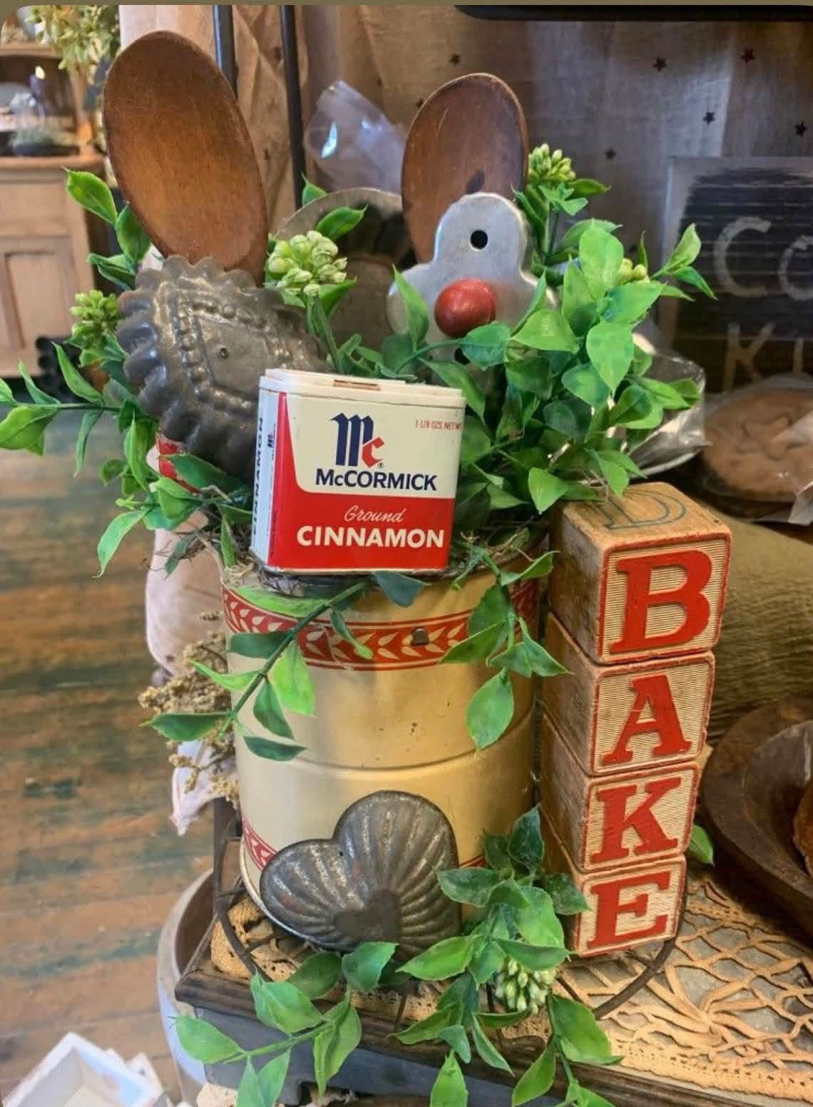 Vintage baking vignette with cinnamon tin, wooden spoons, and letter blocks