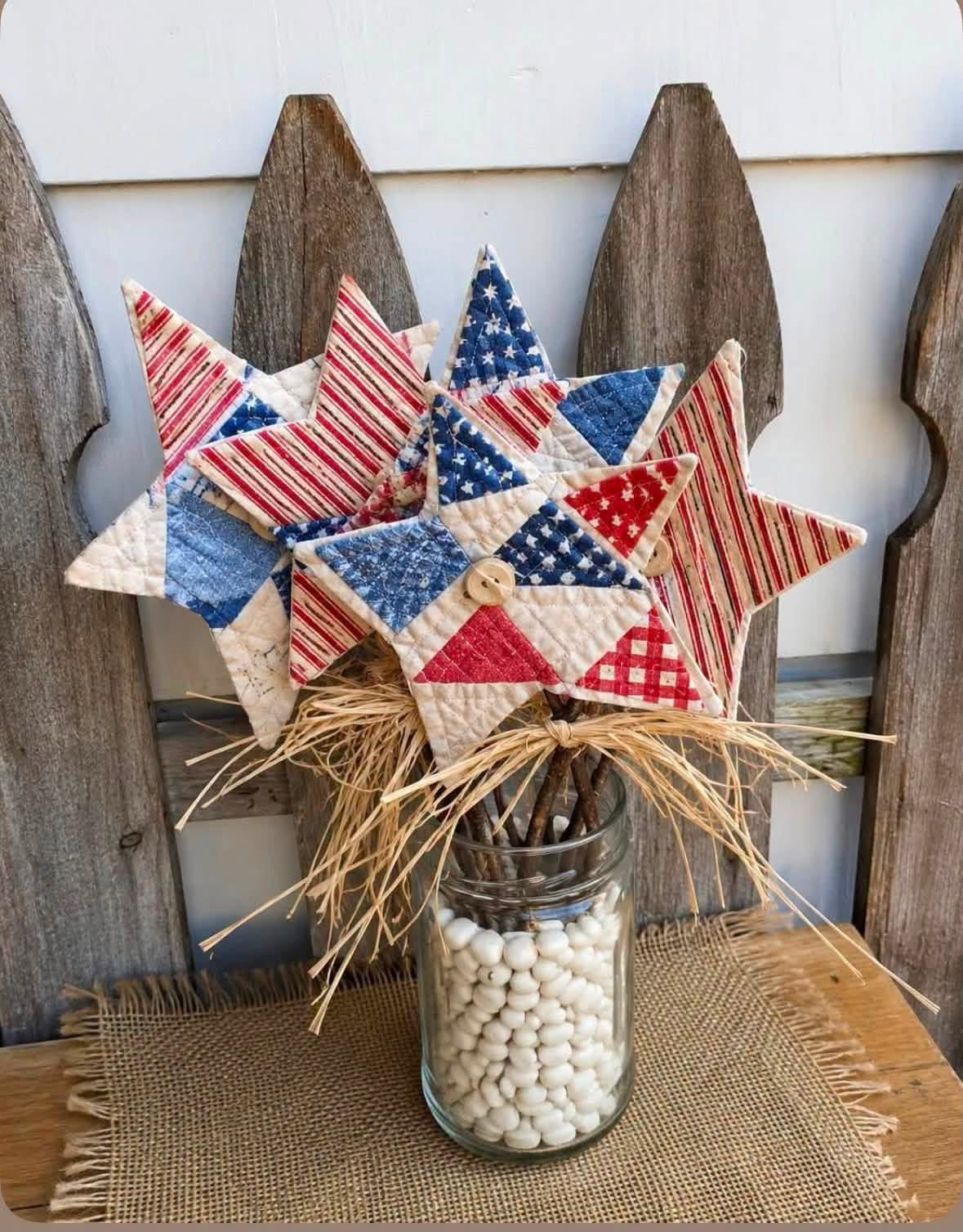 Red white and blue quilted stars on stems in a glass jar