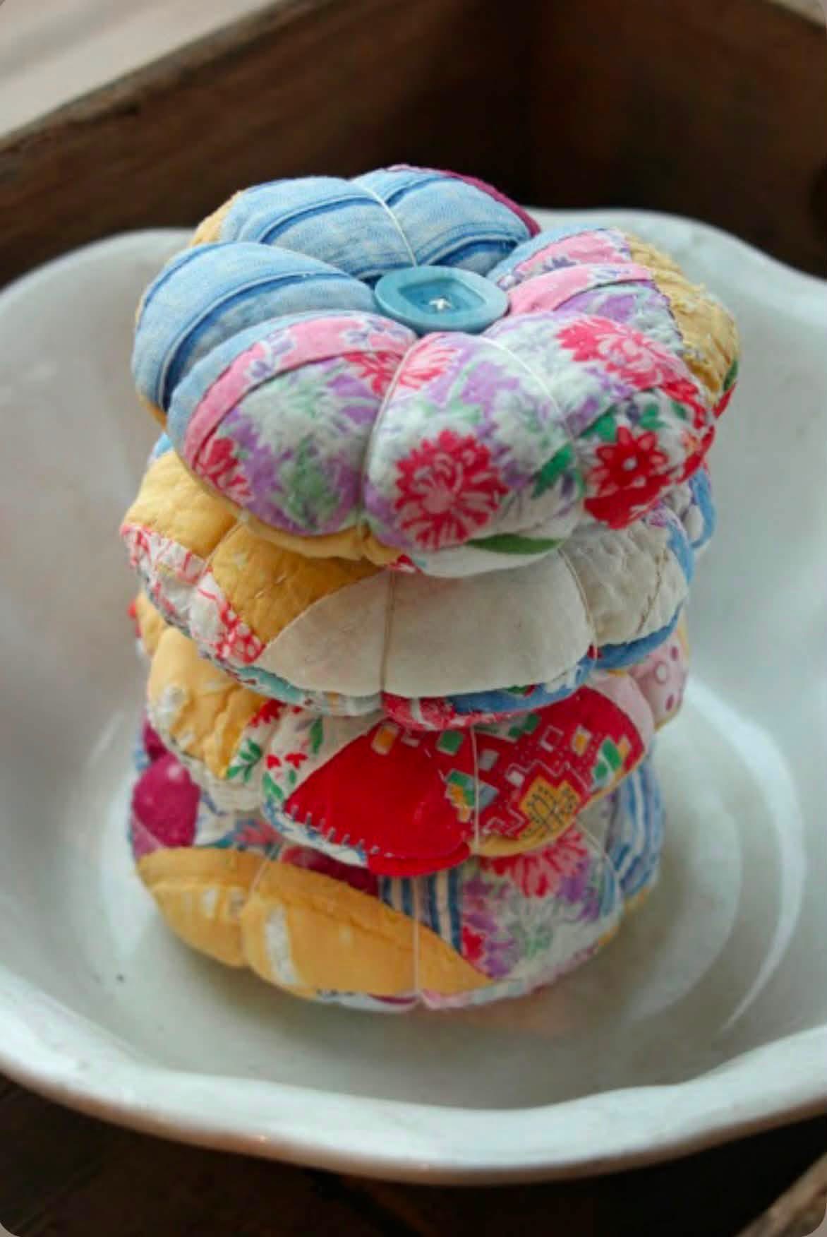 Stacked round patchwork pincushions with button centers