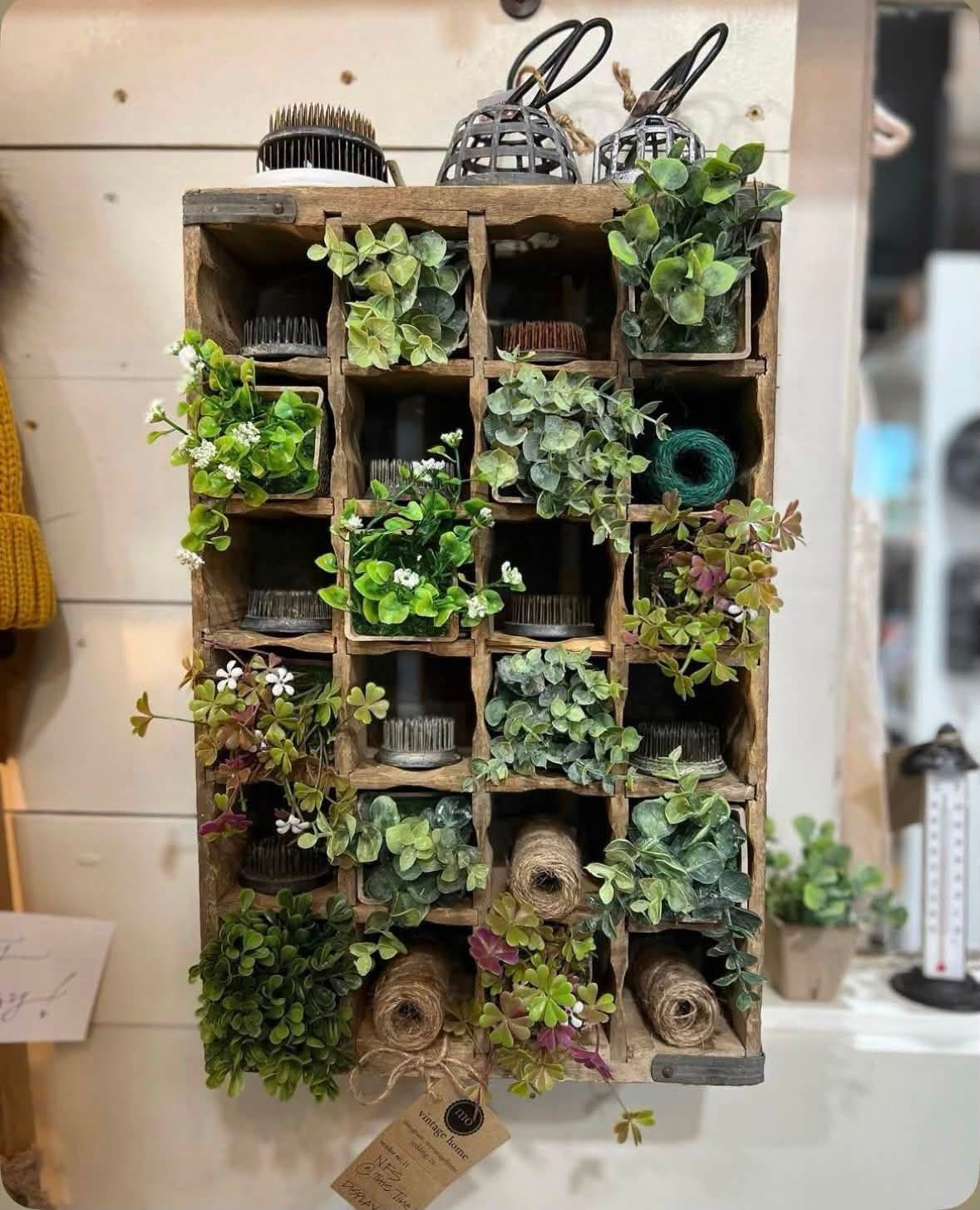 Greenery flower frogs and twine displayed in a wooden compartment crate