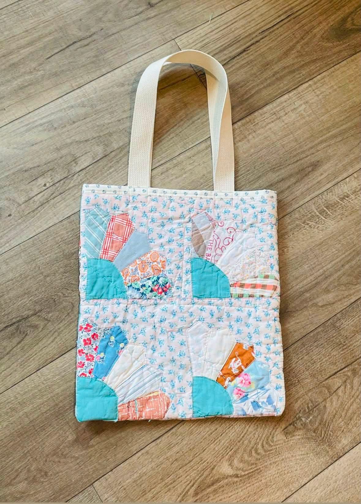 Blue floral patchwork tote bag on a wooden floor