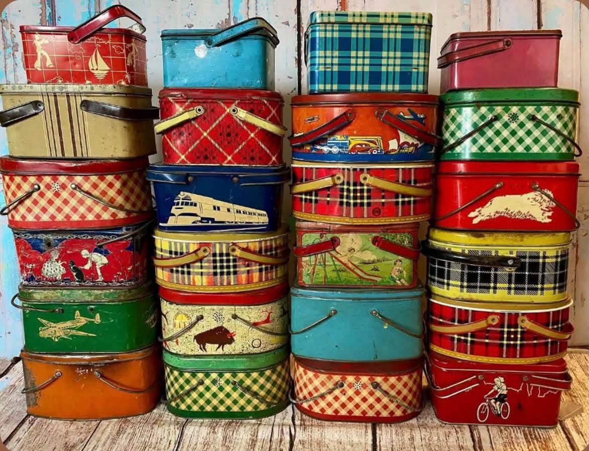Collection of colorful vintage picnic tins with plaid and illustrated designs