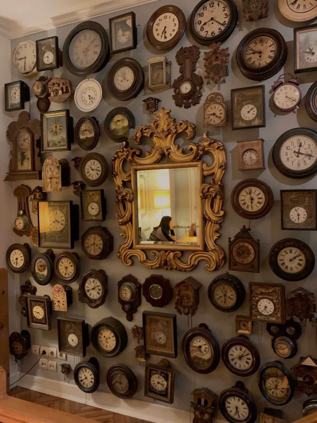 Vintage clocks surrounding an ornate gold mirror