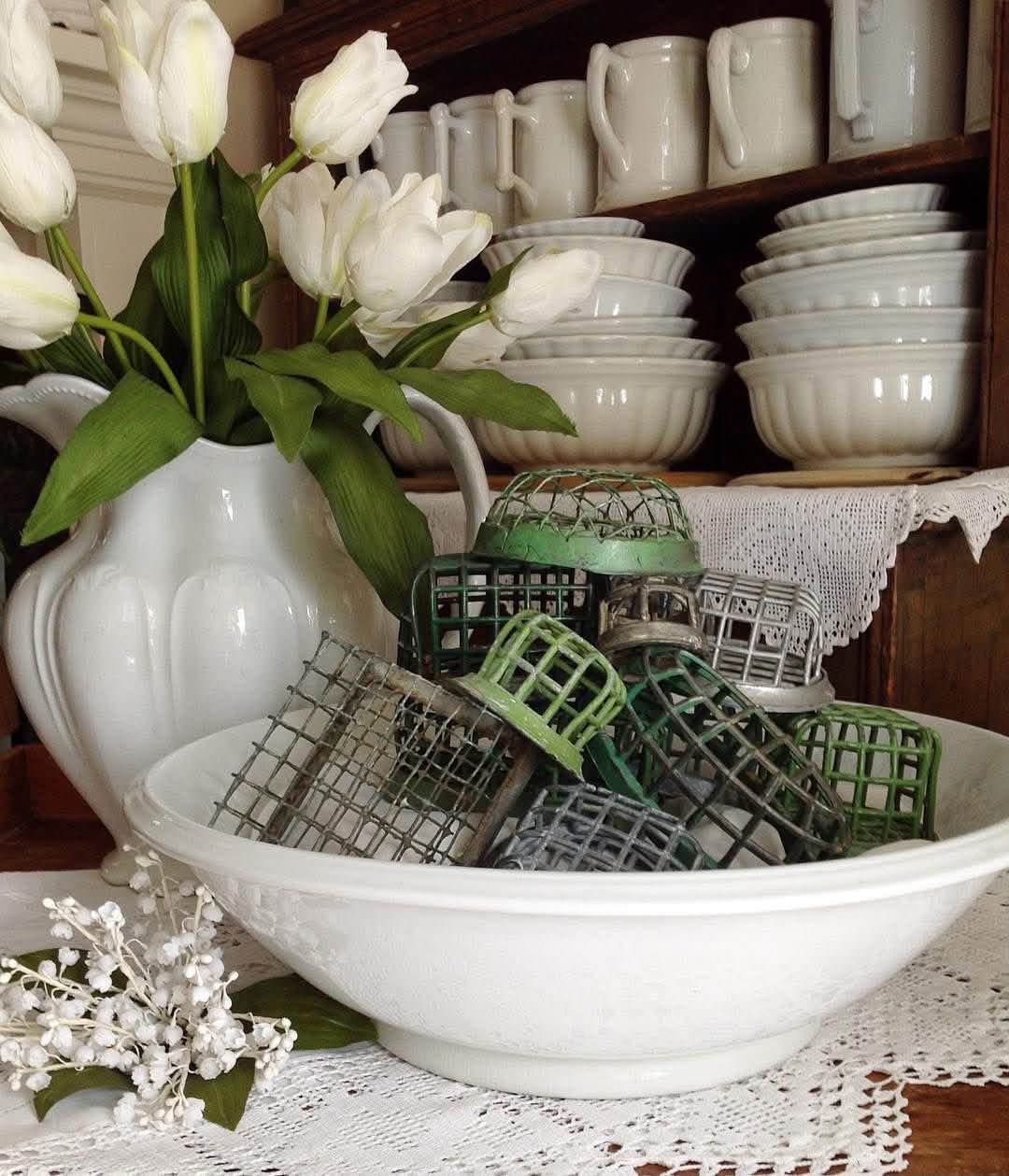 A white bowl filled with green and silver cage flower frogs