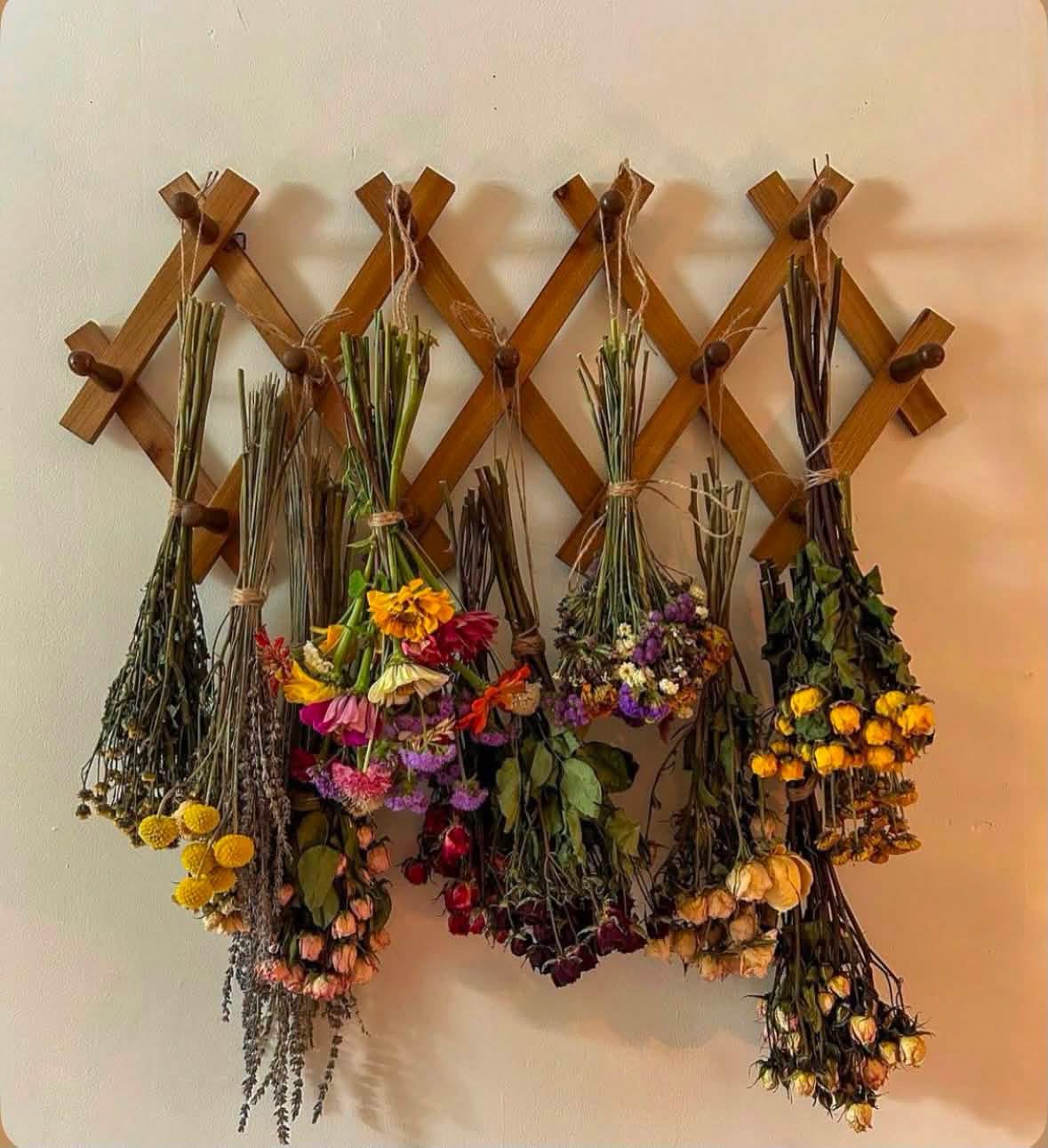 Dried flower bouquets hanging from an accordion wooden rack