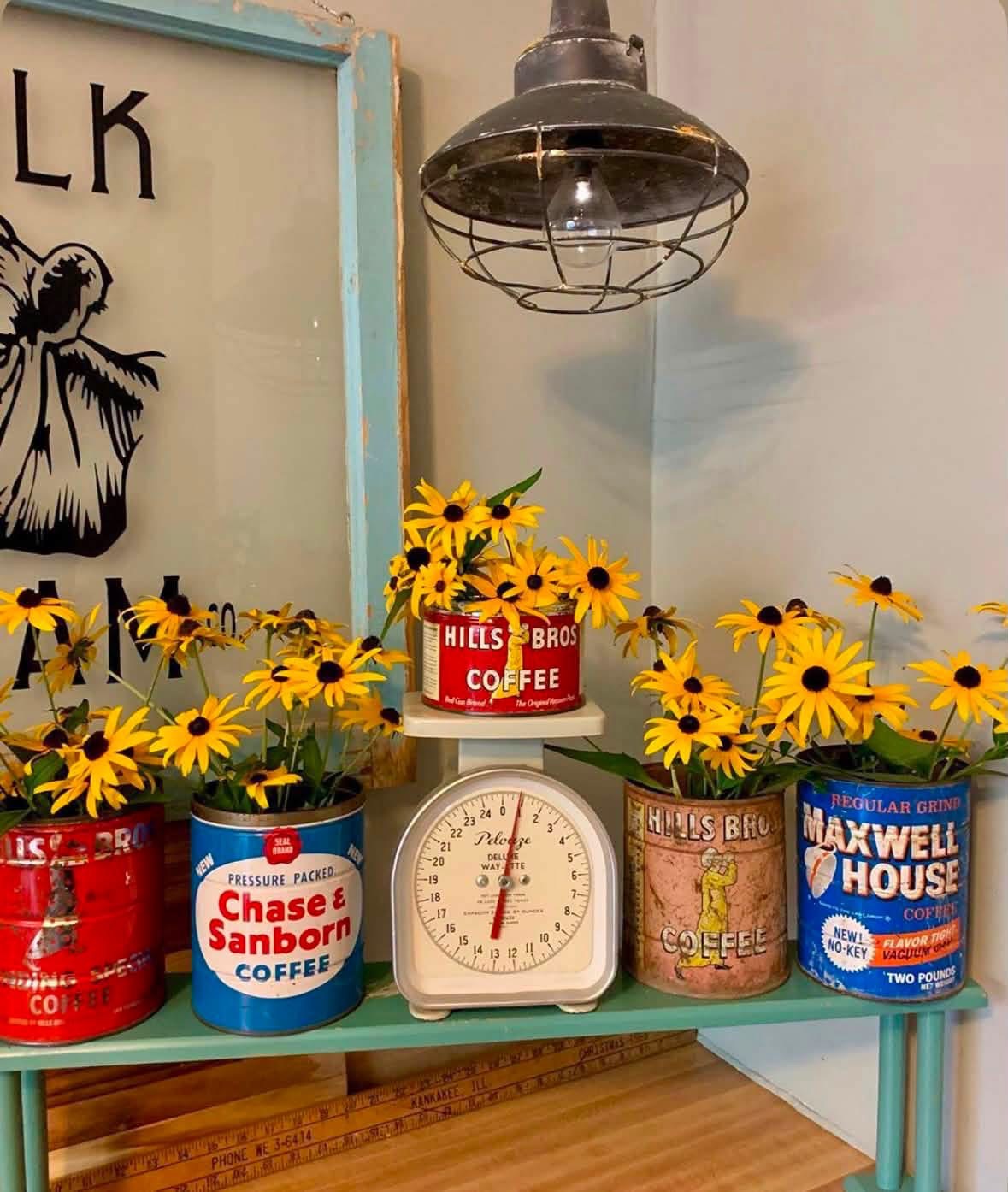 Yellow flowers in vintage coffee tins around a kitchen scale