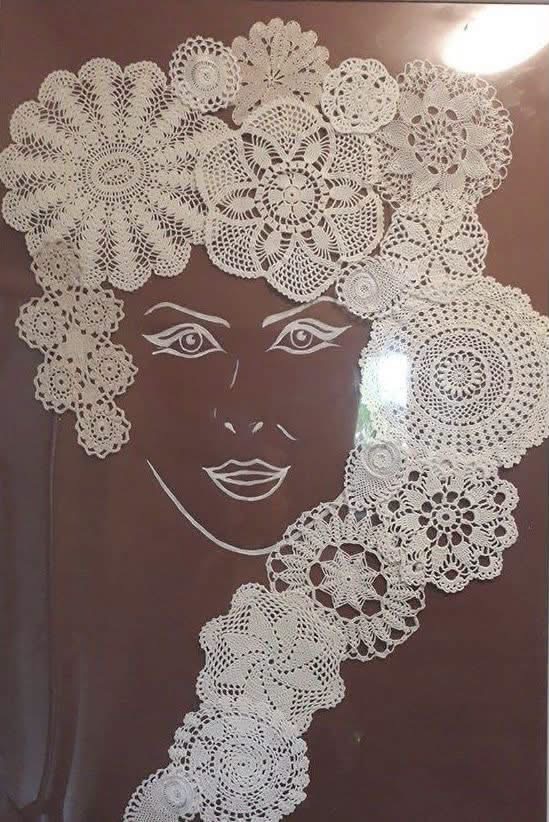A woman’s portrait with flowing hair made from white doilies