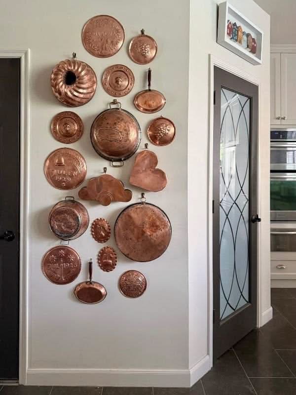 Copper pans and molds on a kitchen wall