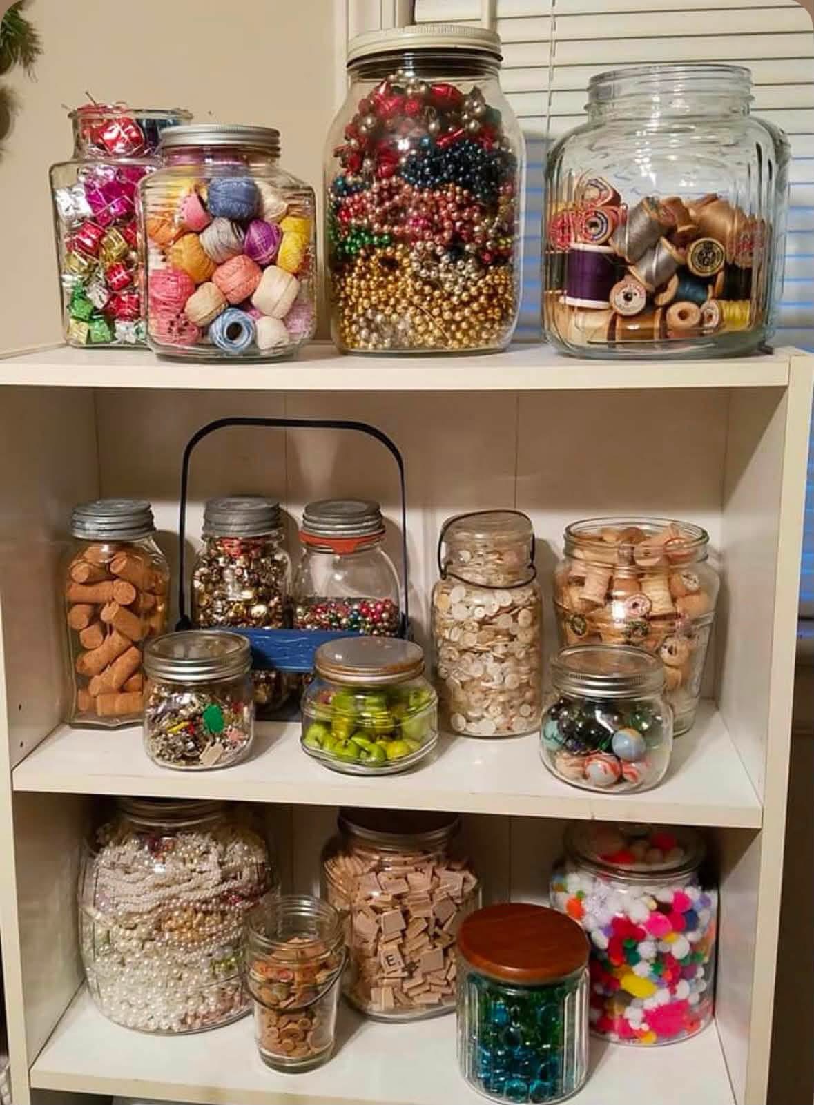 Glass jars holding buttons thread beads and small craft treasures