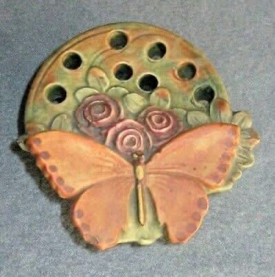 A butterfly and floral ceramic flower frog