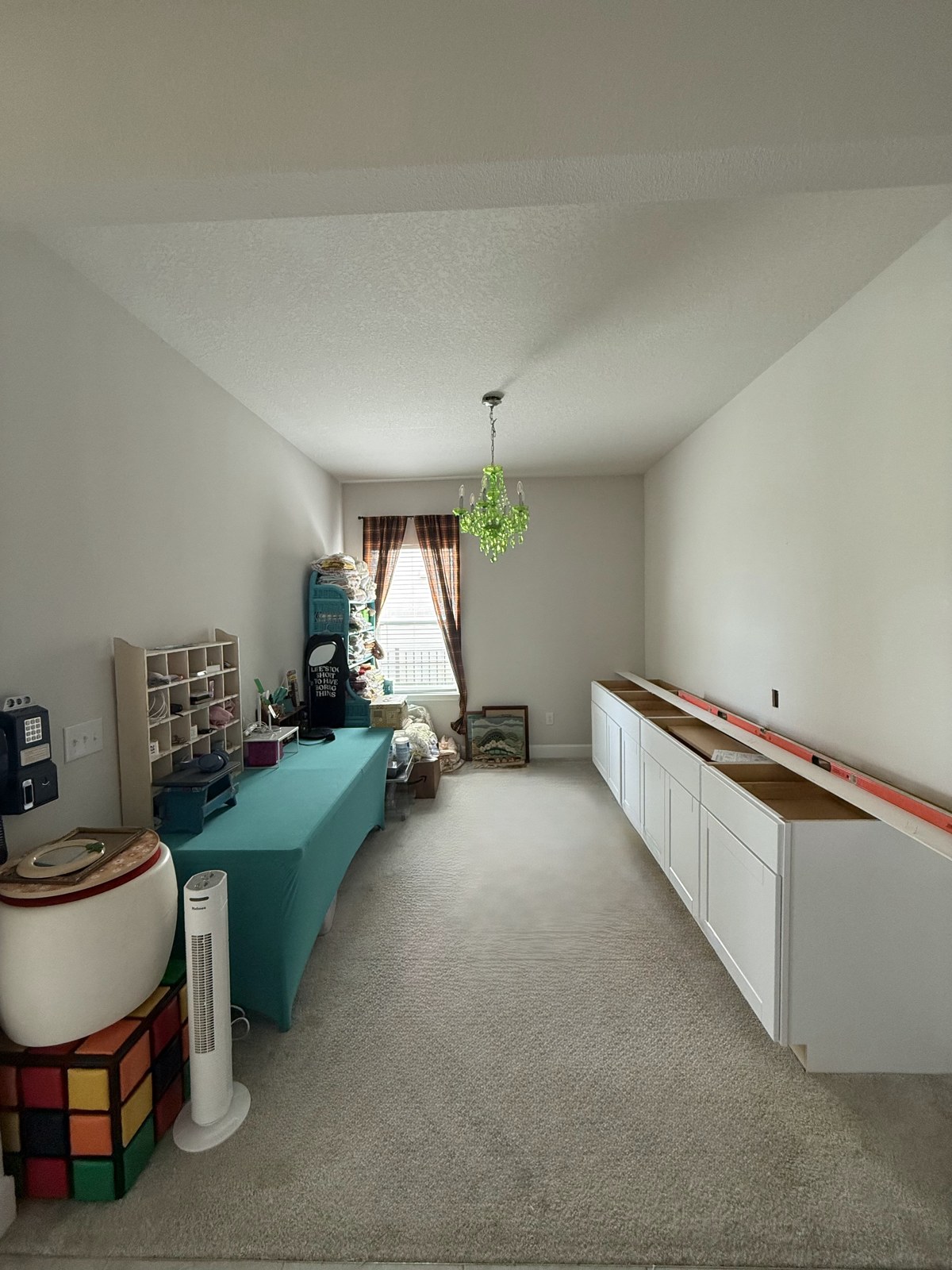 Cabinets being installed along the Whatnot room wall