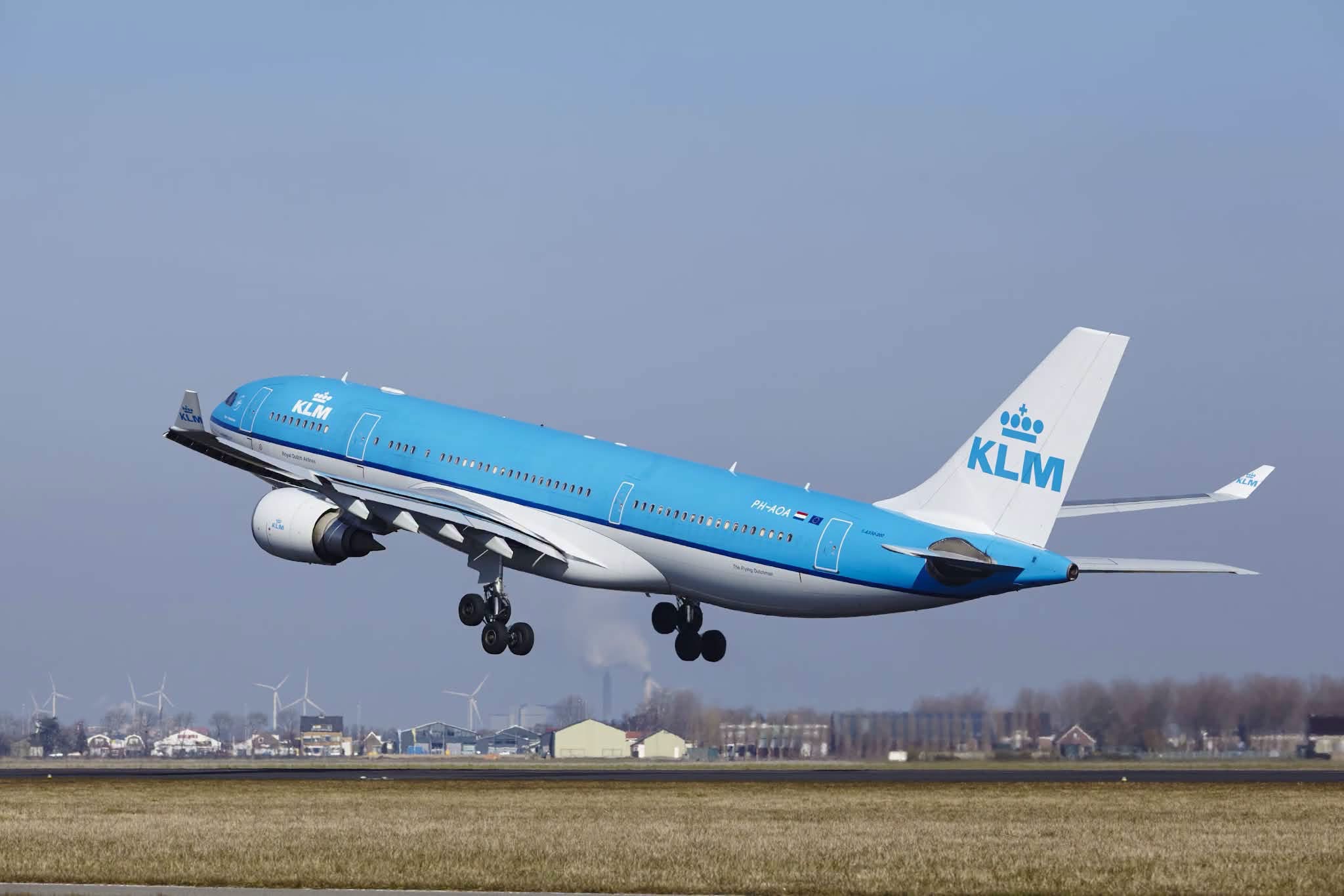 Blue and white KLM passenger aircraft taking off
