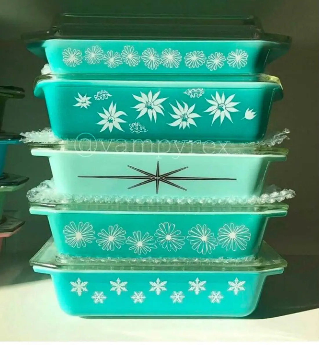 Stacked turquoise rectangular casseroles with floral and star designs