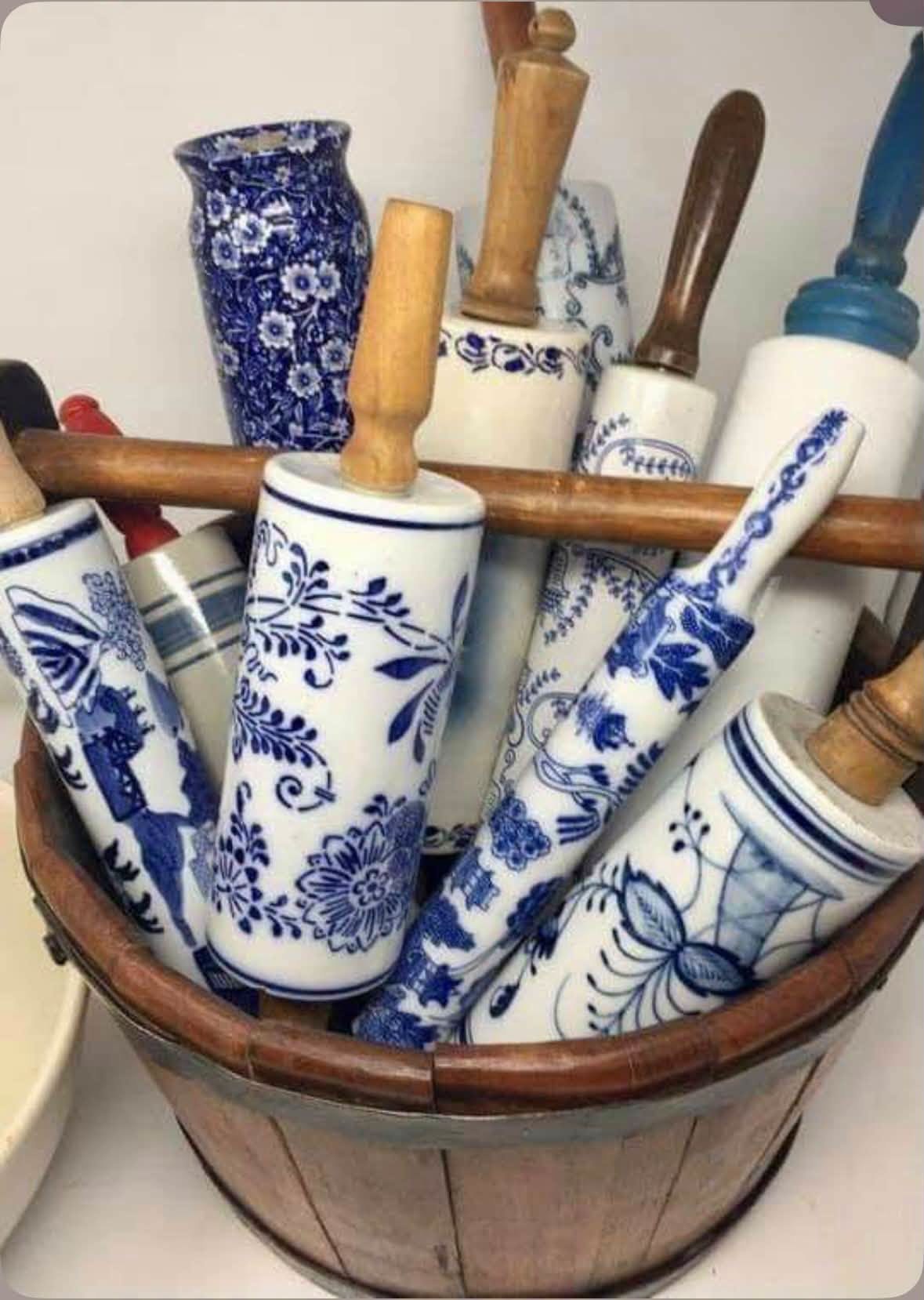 Blue and white ceramic rolling pins gathered in a wooden bucket