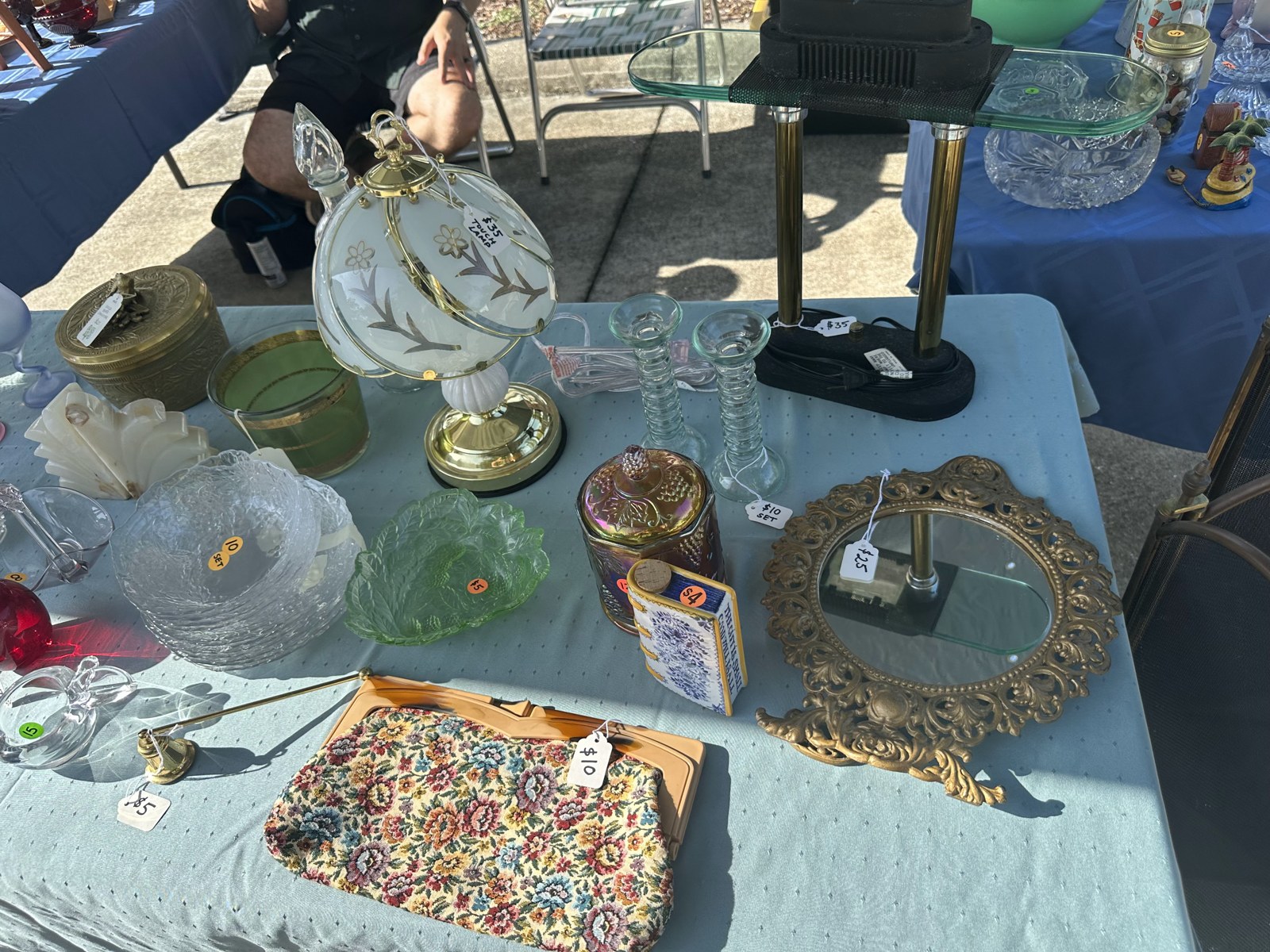 Vintage glassware, plates and a lamp on the outdoor sale table