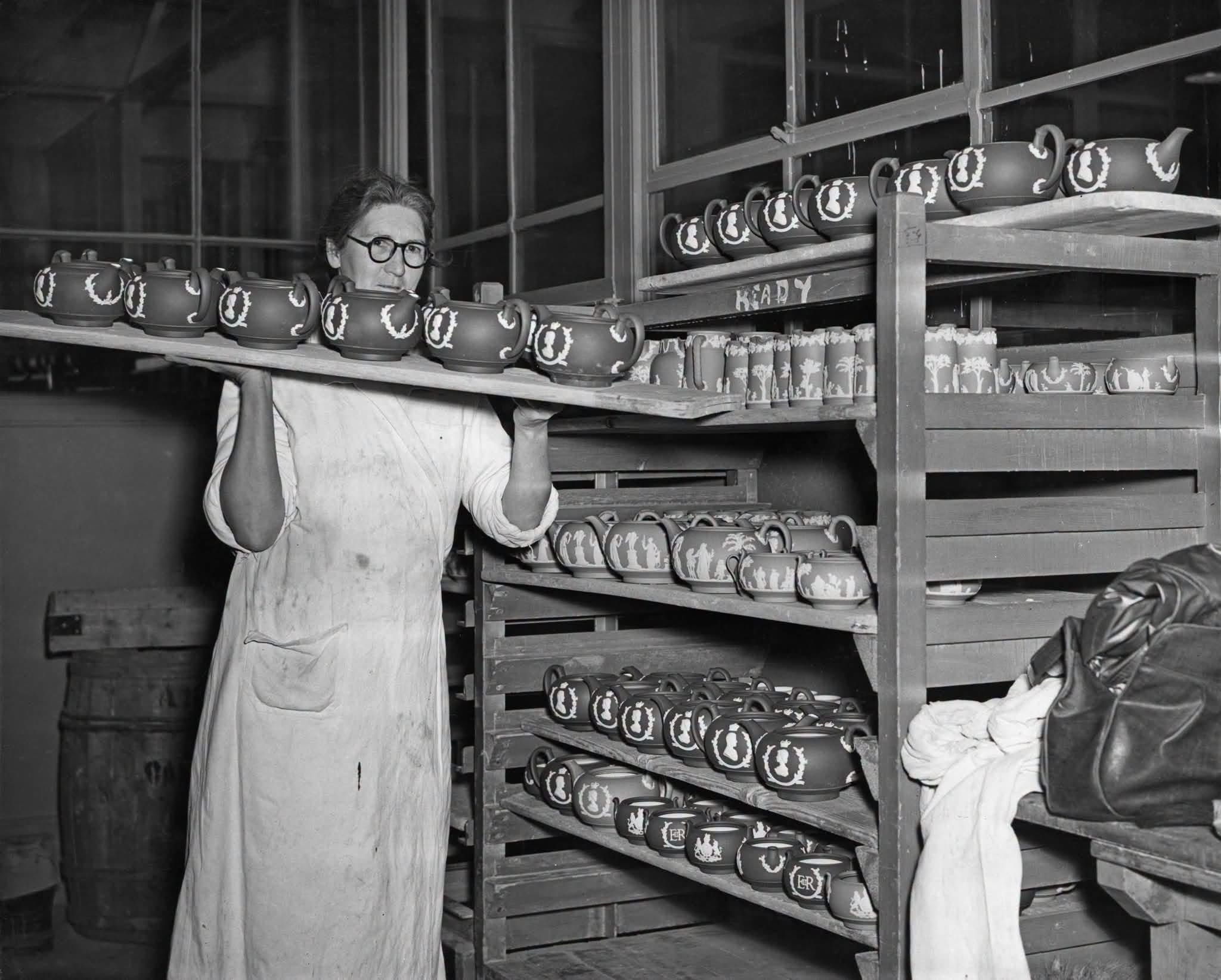 Historic black and white photograph of pottery production and decorated teapots