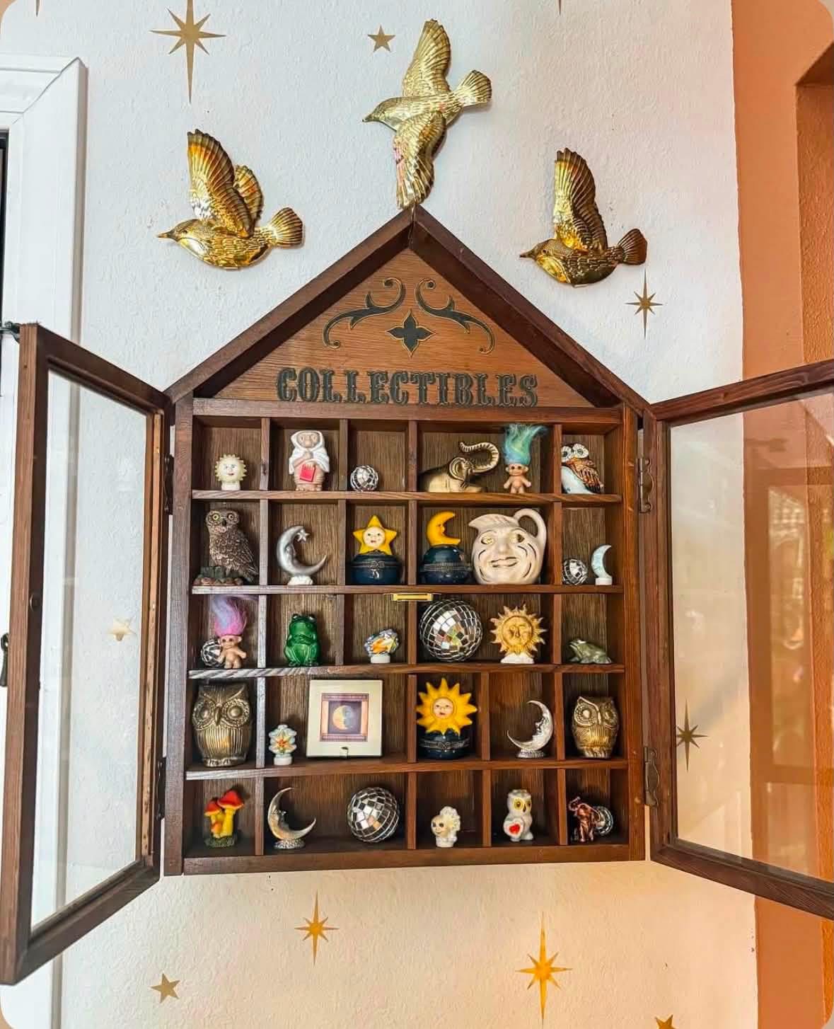 House shaped cabinet with celestial ornaments and small collectibles