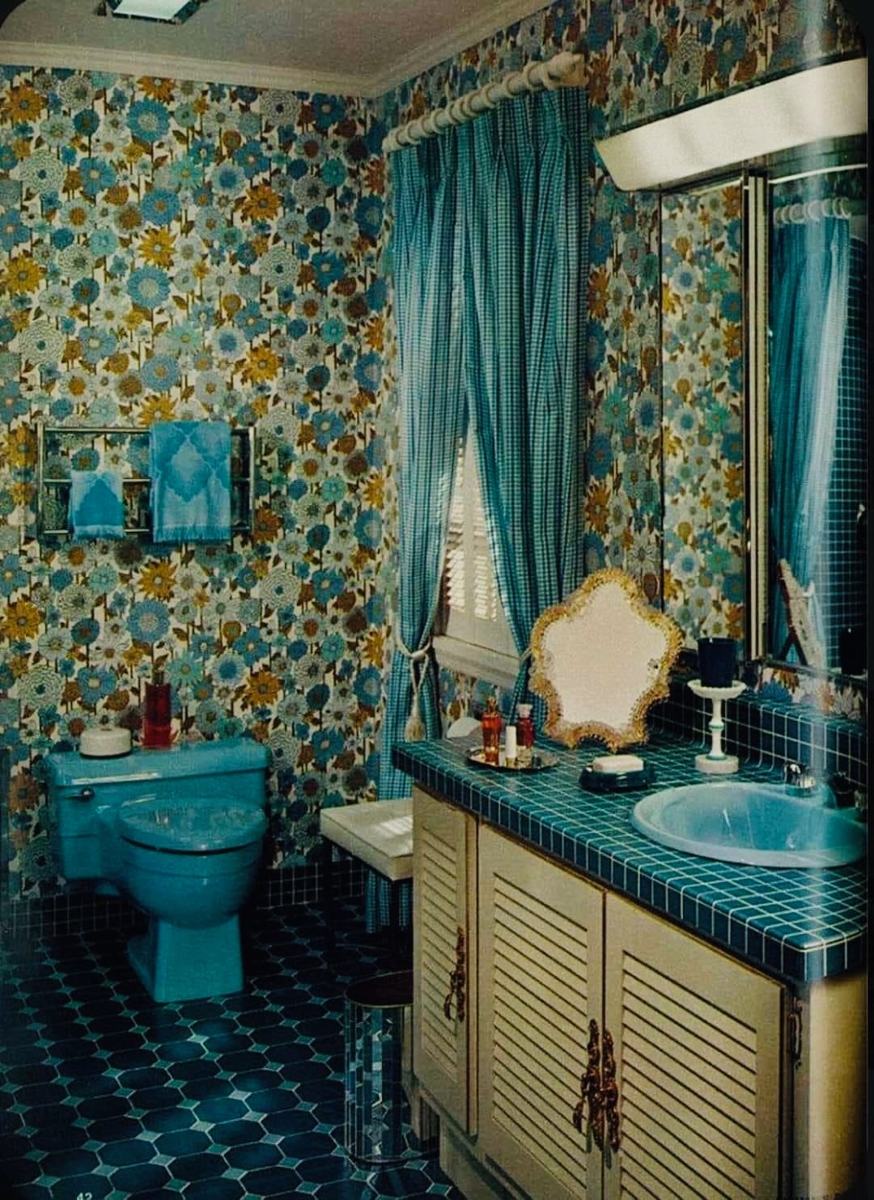 Blue bathroom with floral wallpaper and turquoise fixtures