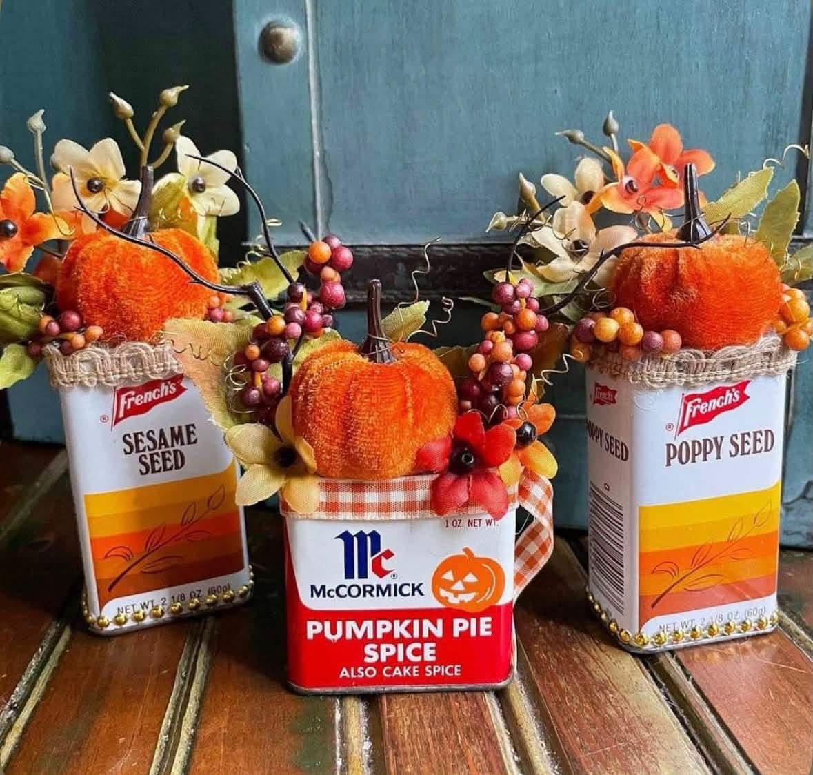 Vintage spice tins filled with miniature pumpkins and autumn flowers