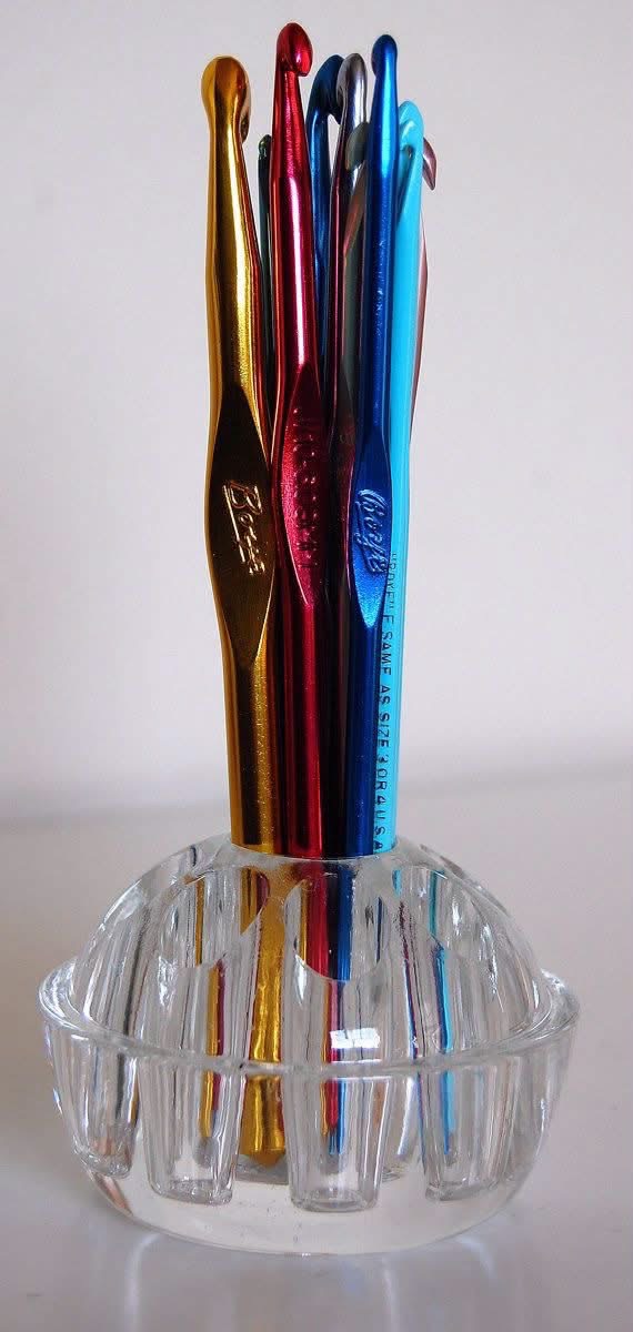 Colorful crochet hooks standing in a clear glass flower frog