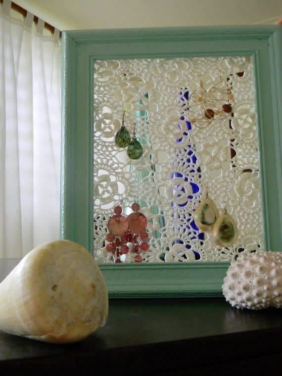 A turquoise frame with lace used to display earrings
