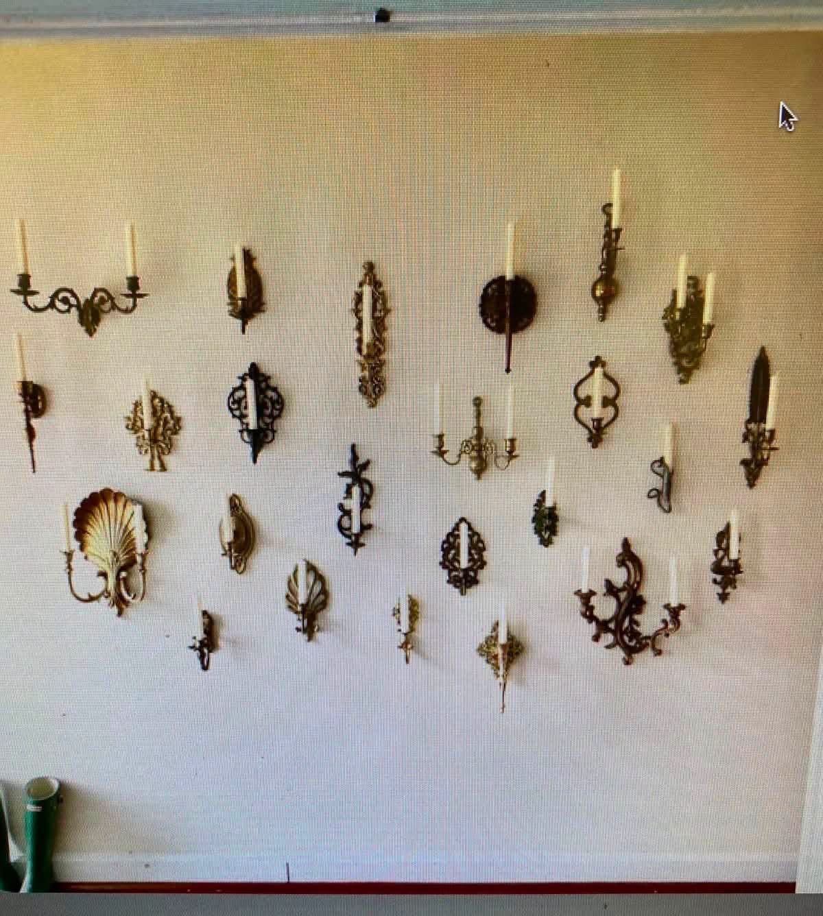 Assorted decorative candle sconces on a white wall