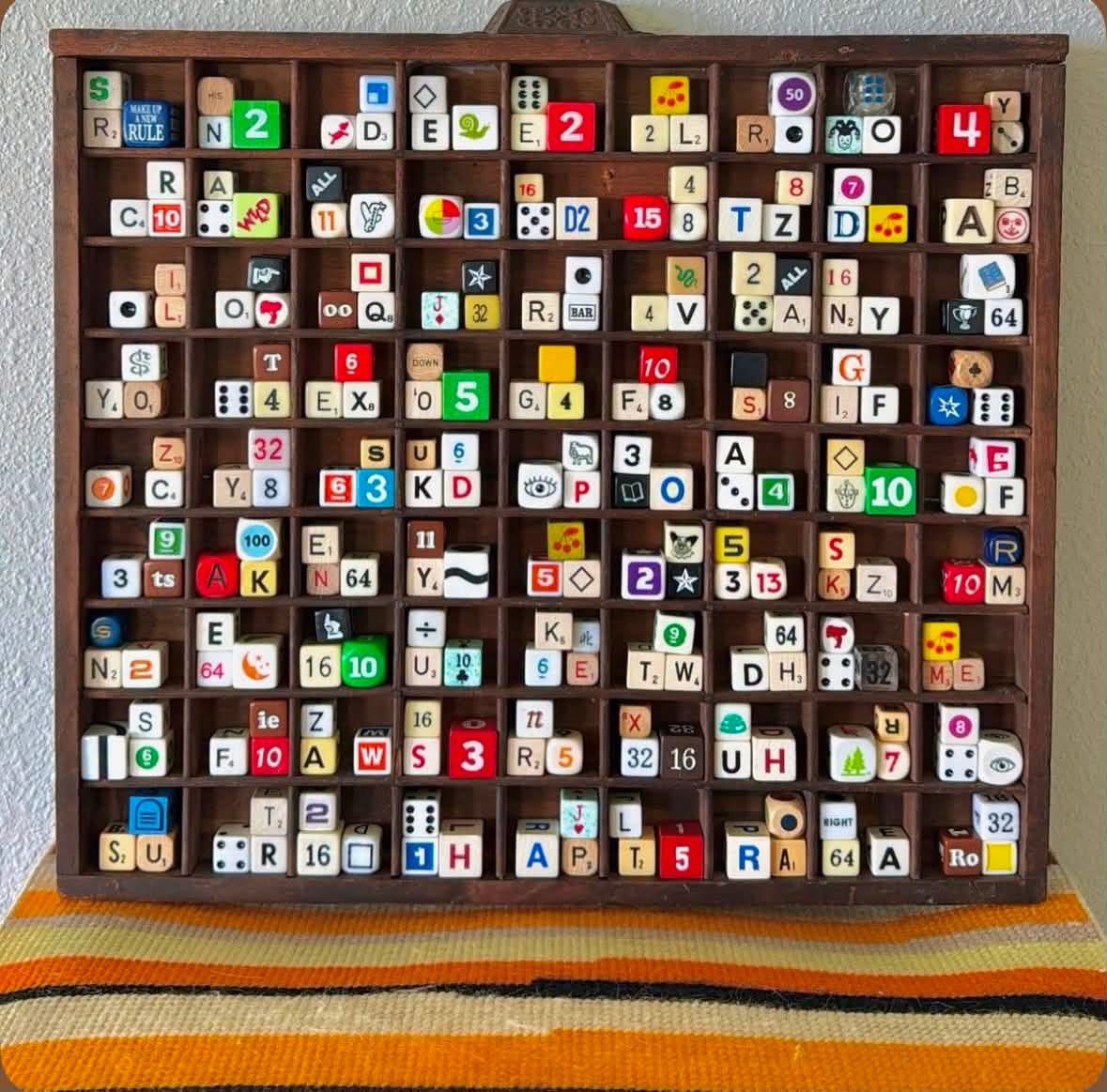 House of Coop’s dice display in a wooden compartment shelf