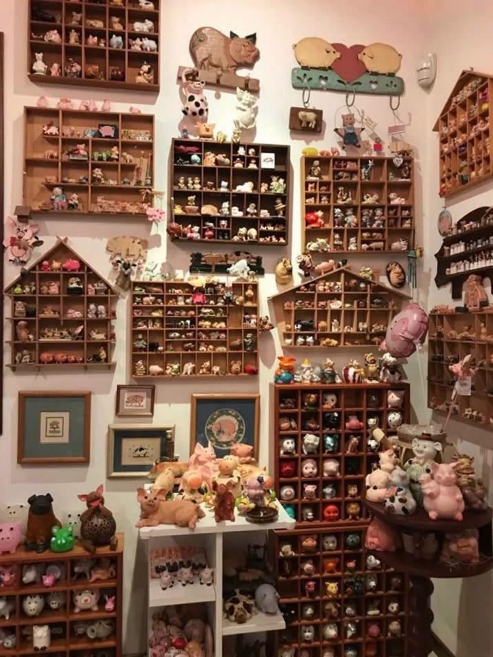 Wooden cubby shelves filled with tiny pig figurines and trinkets