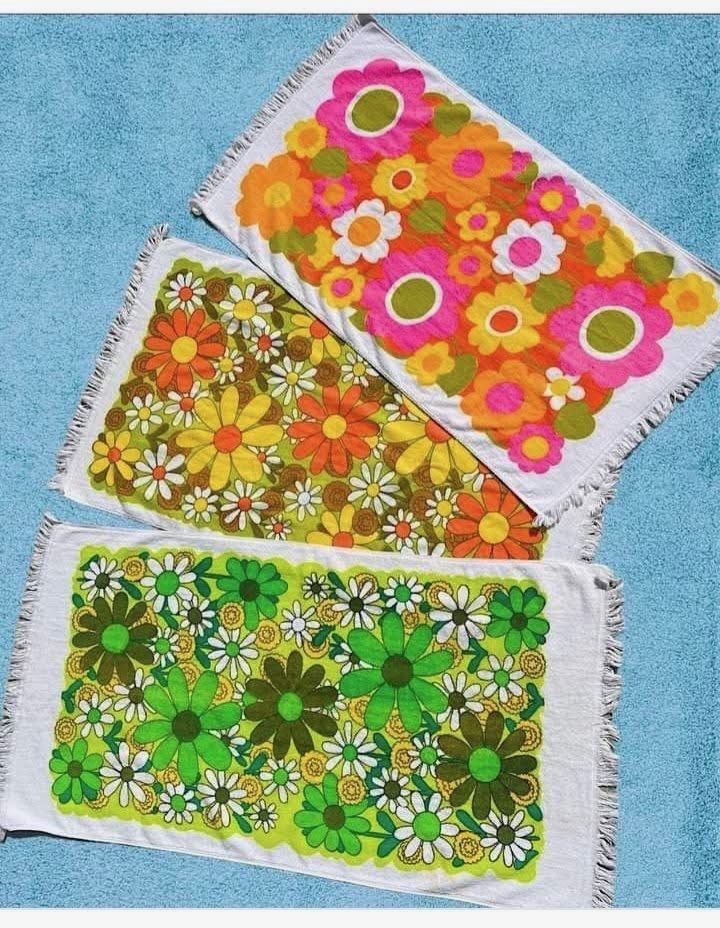 Three colorful floral towels with fringed edges