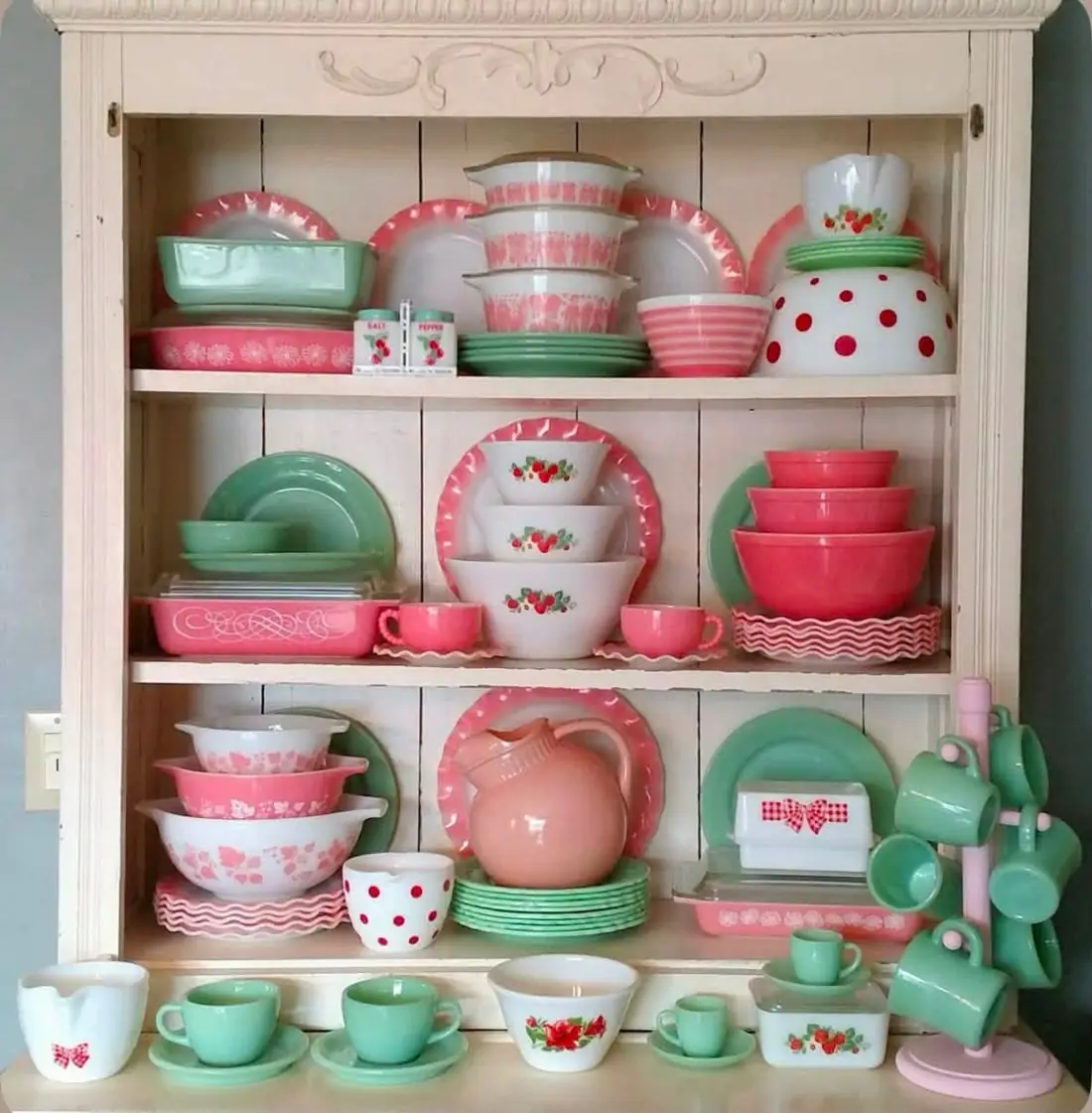 Pink and mint dishes with floral bowls on a white hutch