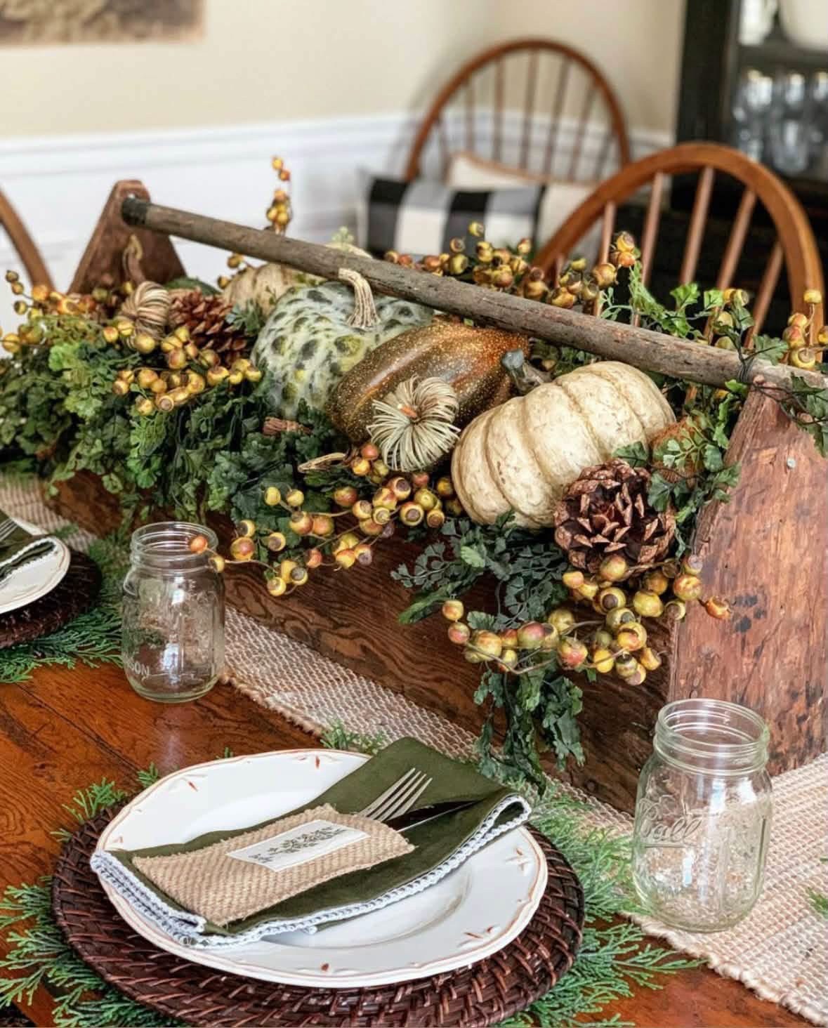 Wooden toolbox filled with pumpkins and greenery on an autumn table