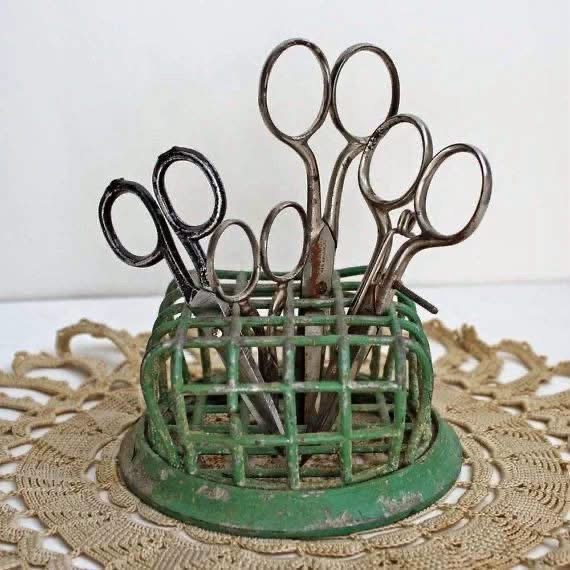 Vintage scissors standing in a green cage flower frog on lace