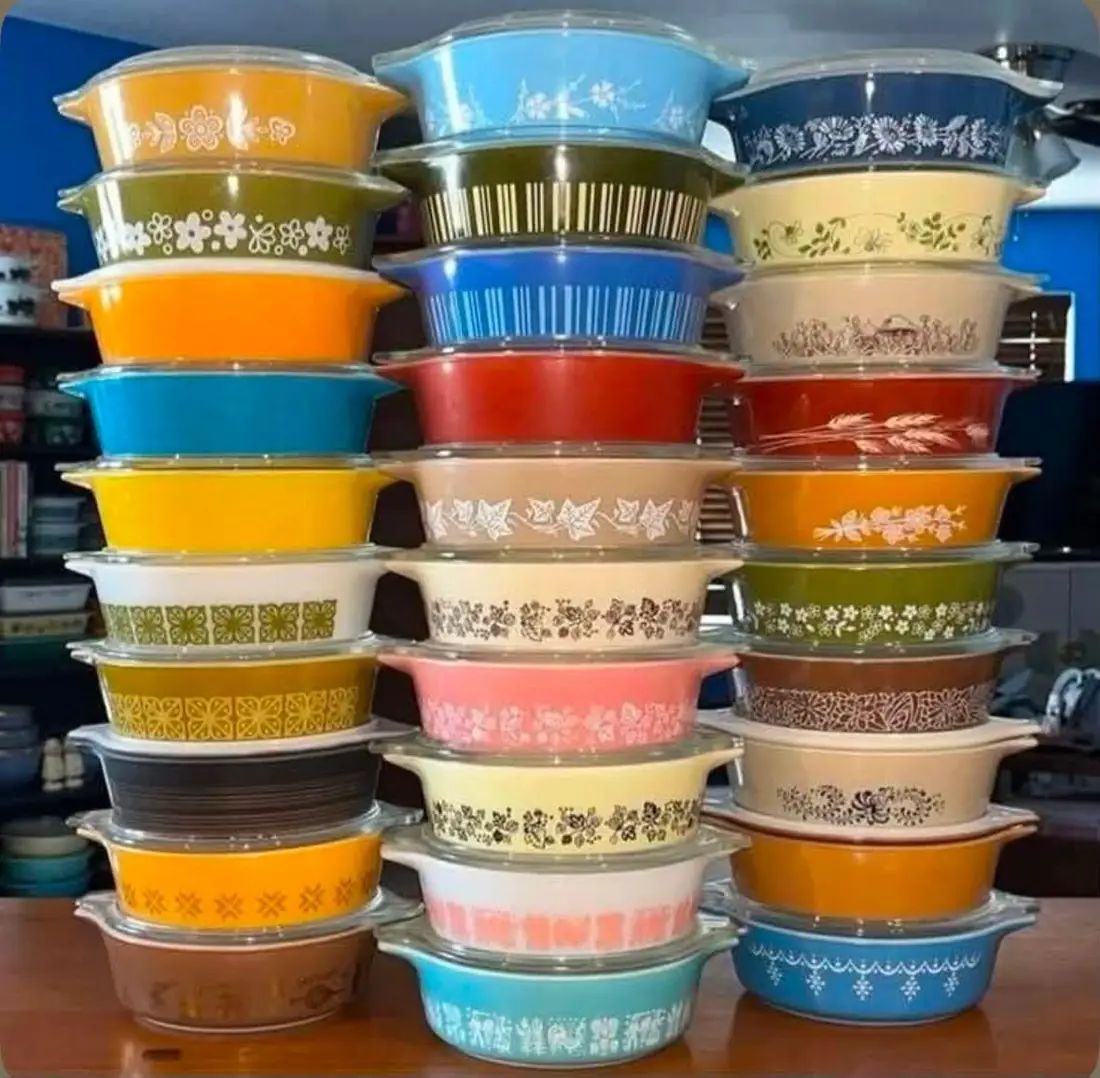 Three tall stacks of colorful patterned Pyrex casseroles