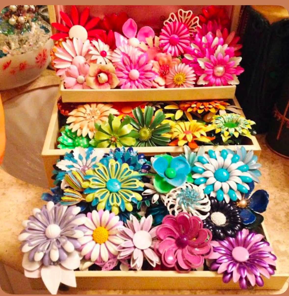 Colorful flower brooches arranged in shallow trays
