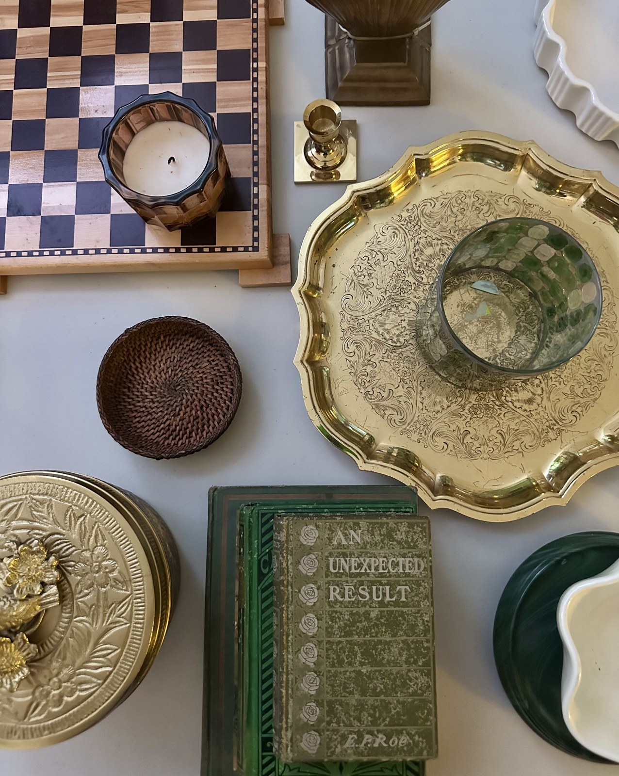 Thrifted decorative trays, a clock and framed pieces arranged together