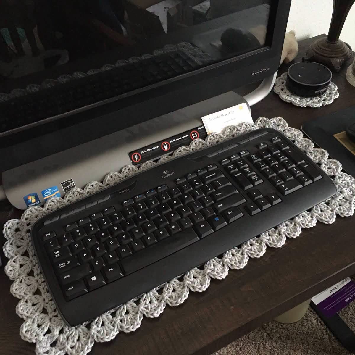 A crocheted mat beneath a computer keyboard