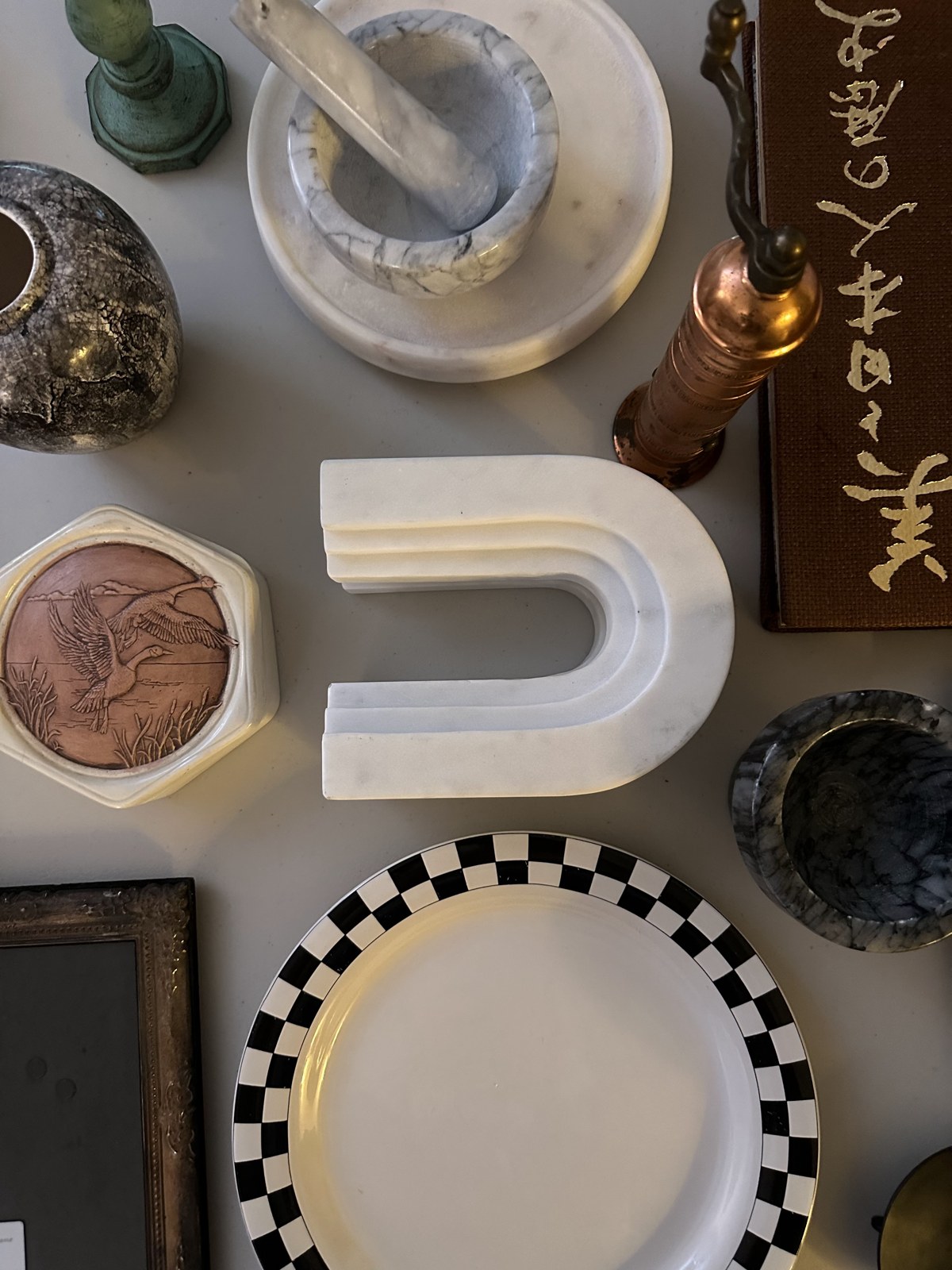 A collection of thrifted plates, marble pieces and decorative objects