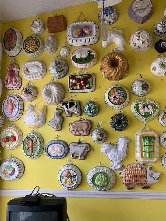 Decorative ceramic molds in many shapes on a yellow wall