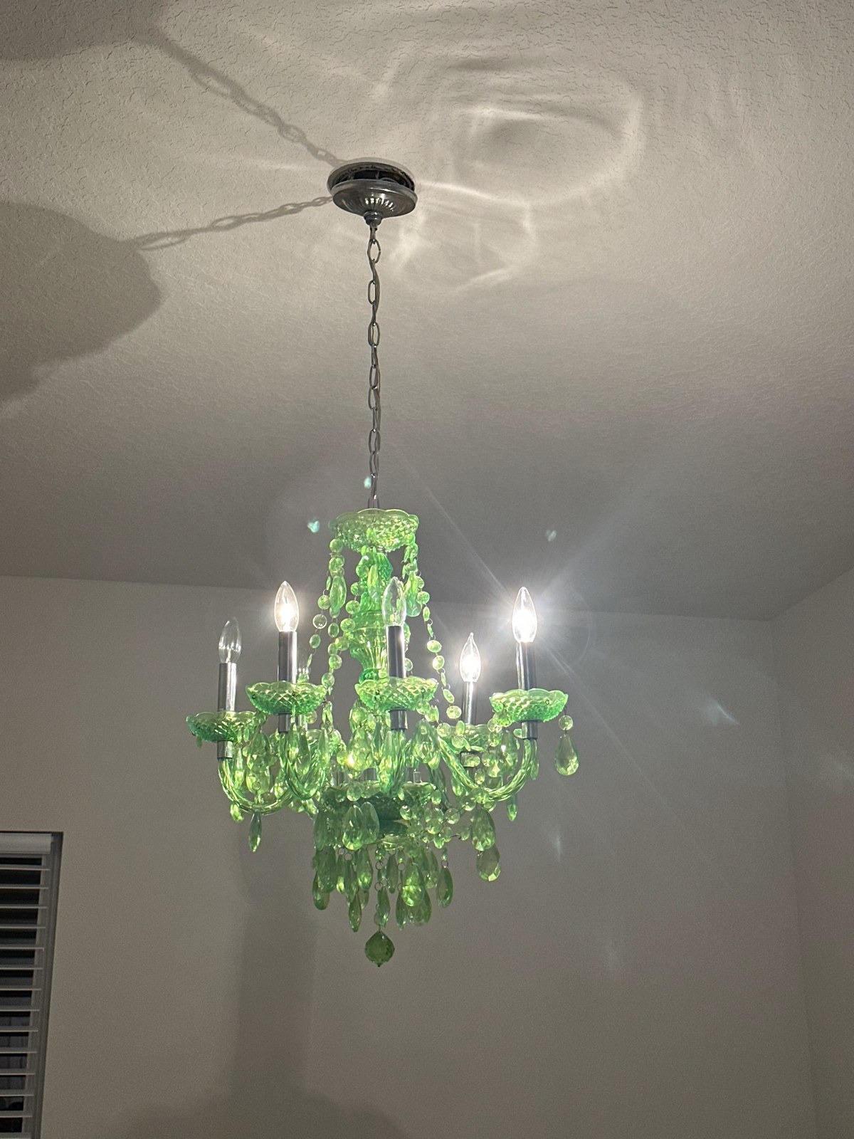 The green chandelier hanging in the first home