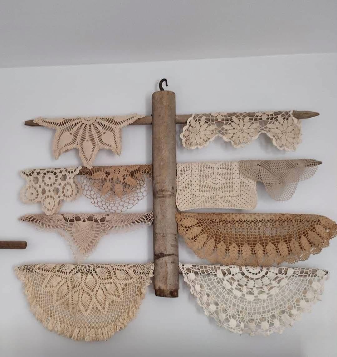 Doilies draped over a rustic wooden wall rack