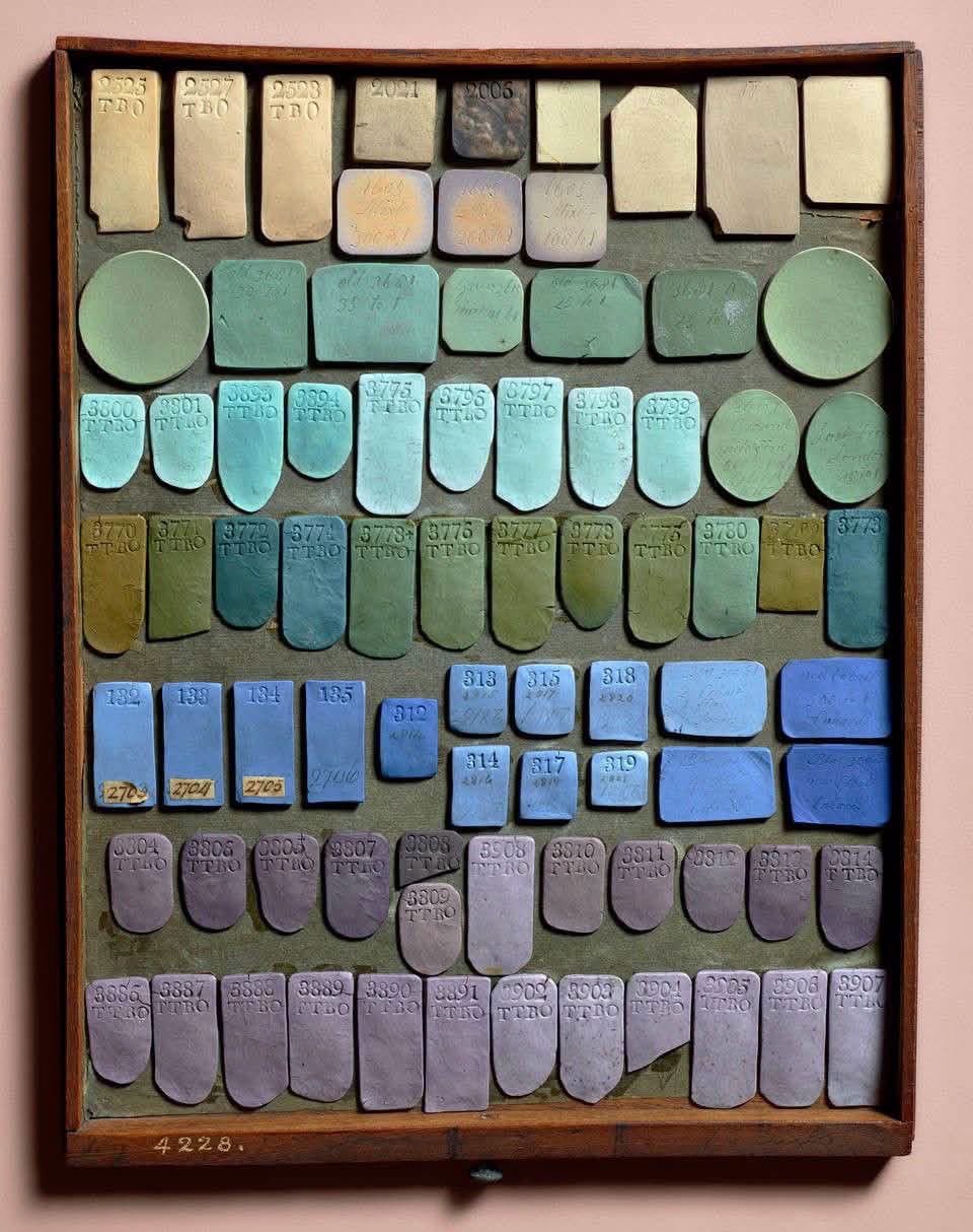 Tray of historical pottery color trials in yellow, green, blue and lilac