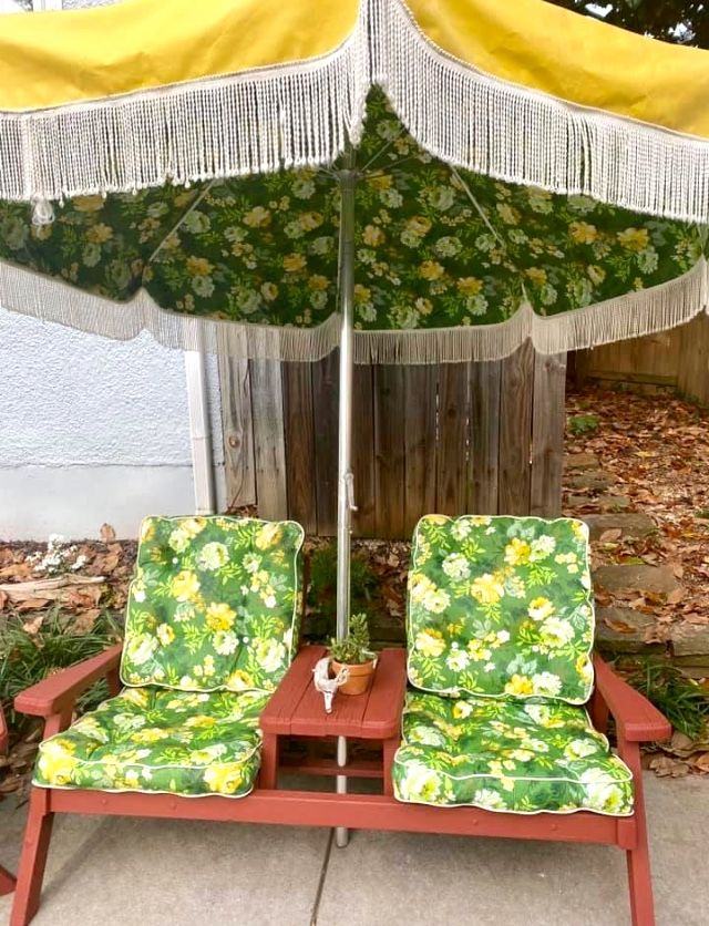 Green floral outdoor cushions and a fringed garden umbrella