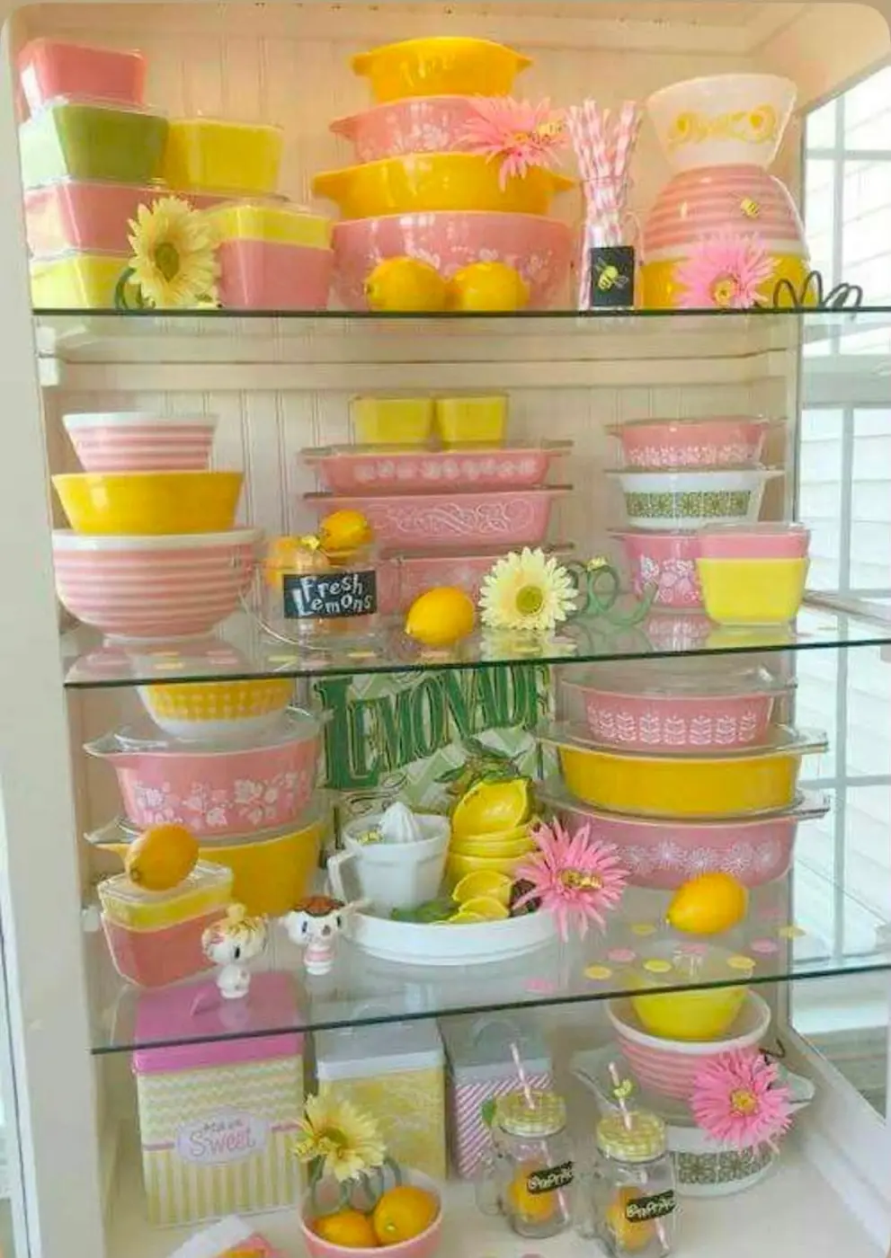 Pink and yellow bowls displayed with lemons and flowers