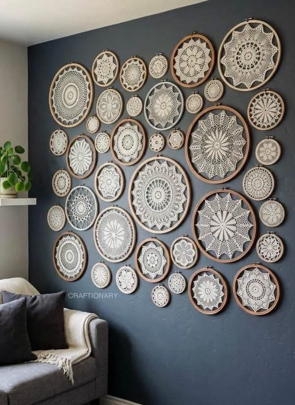 Doilies in embroidery hoops arranged on a dark blue wall