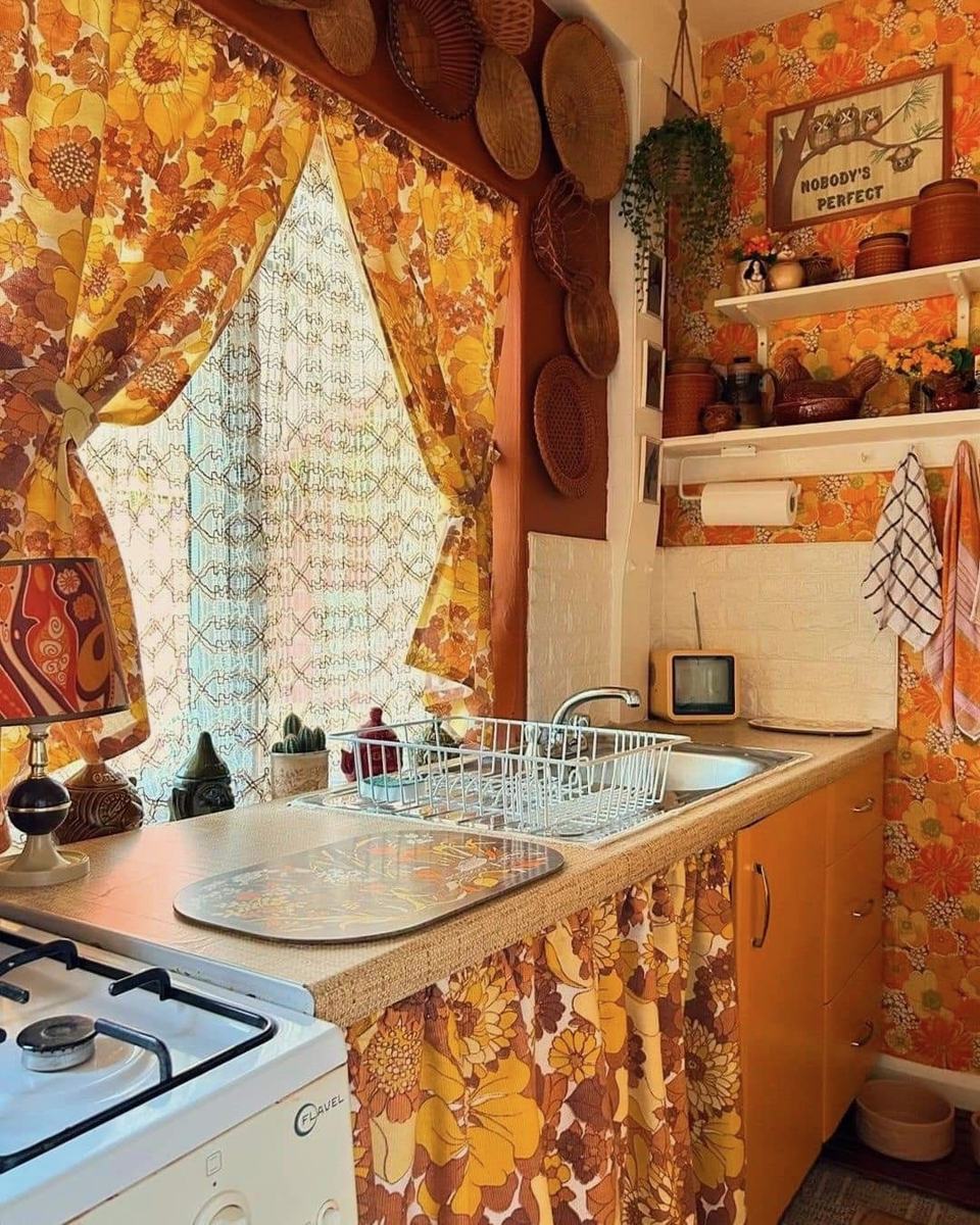 Orange floral curtains and wallpaper in a vintage kitchen