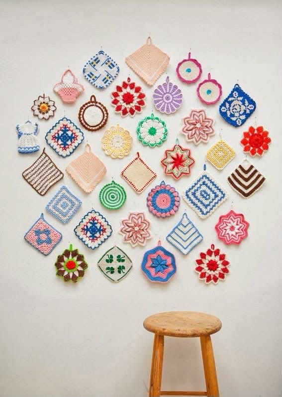 Colorful crocheted potholders arranged above a wooden stool