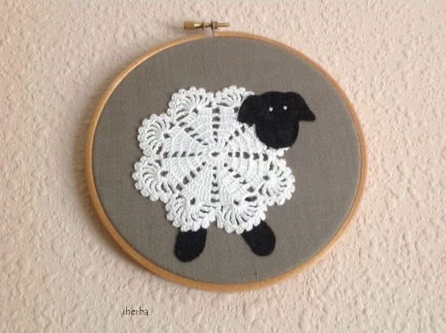 A sheep made from a white doily in an embroidery hoop
