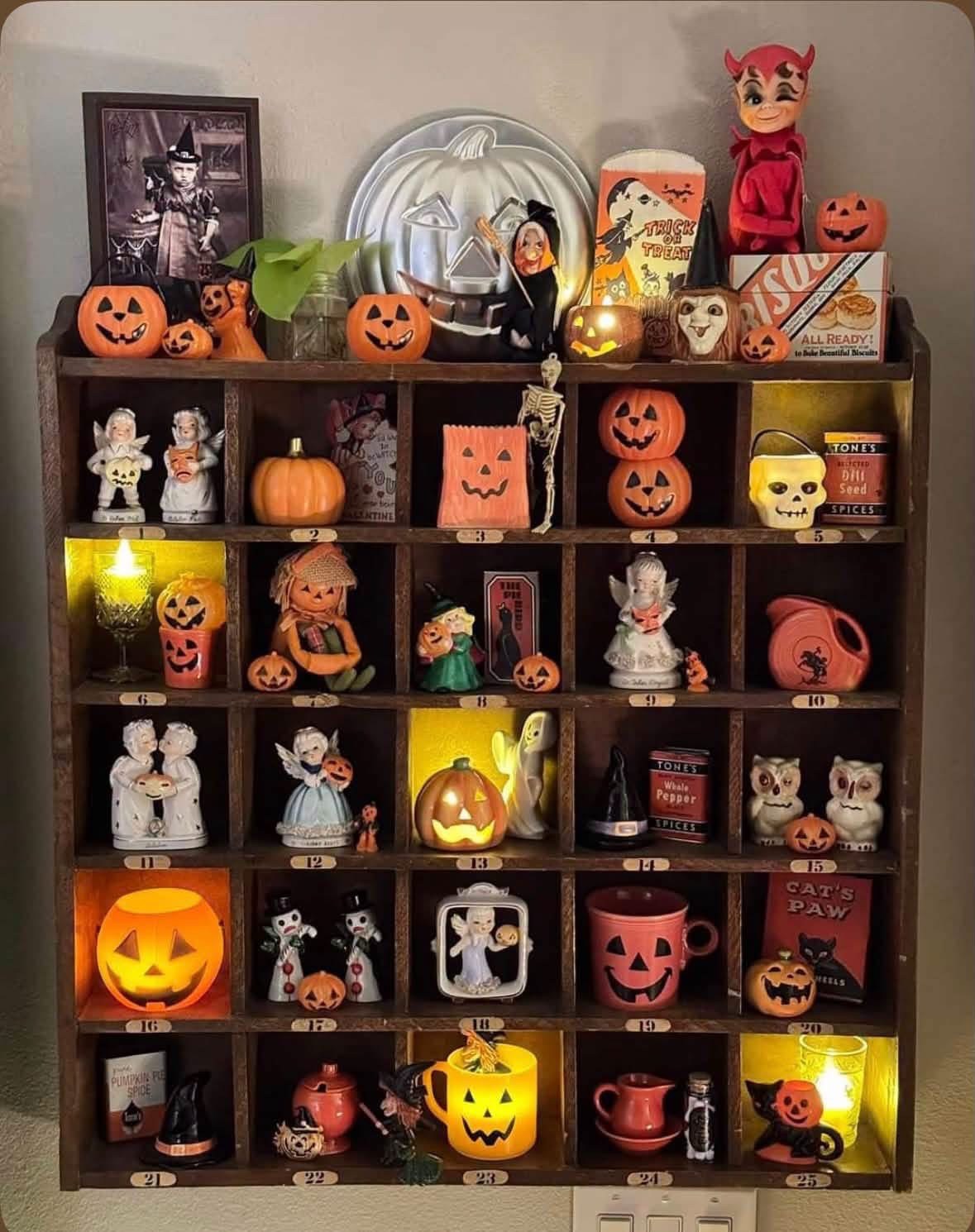 Wall cubby filled with vintage Halloween figurines and pumpkins