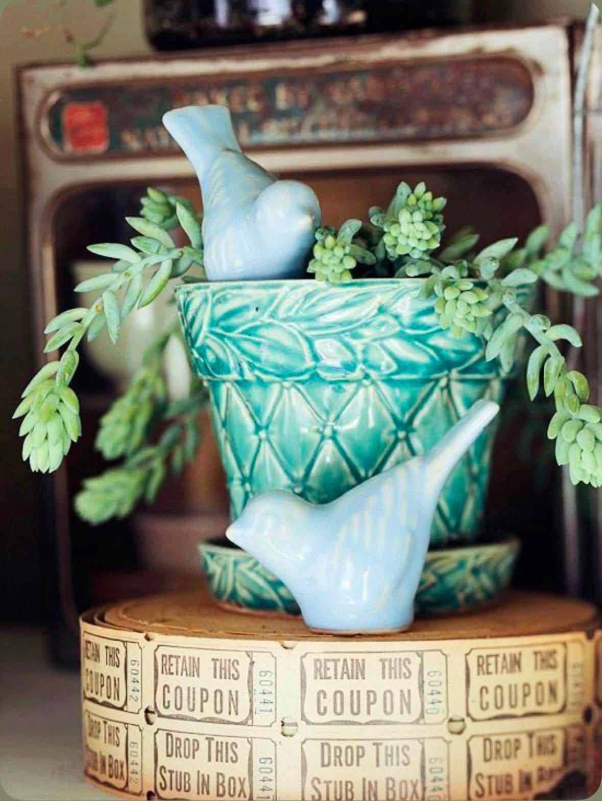 Trailing greenery in turquoise pottery with blue bird figurines