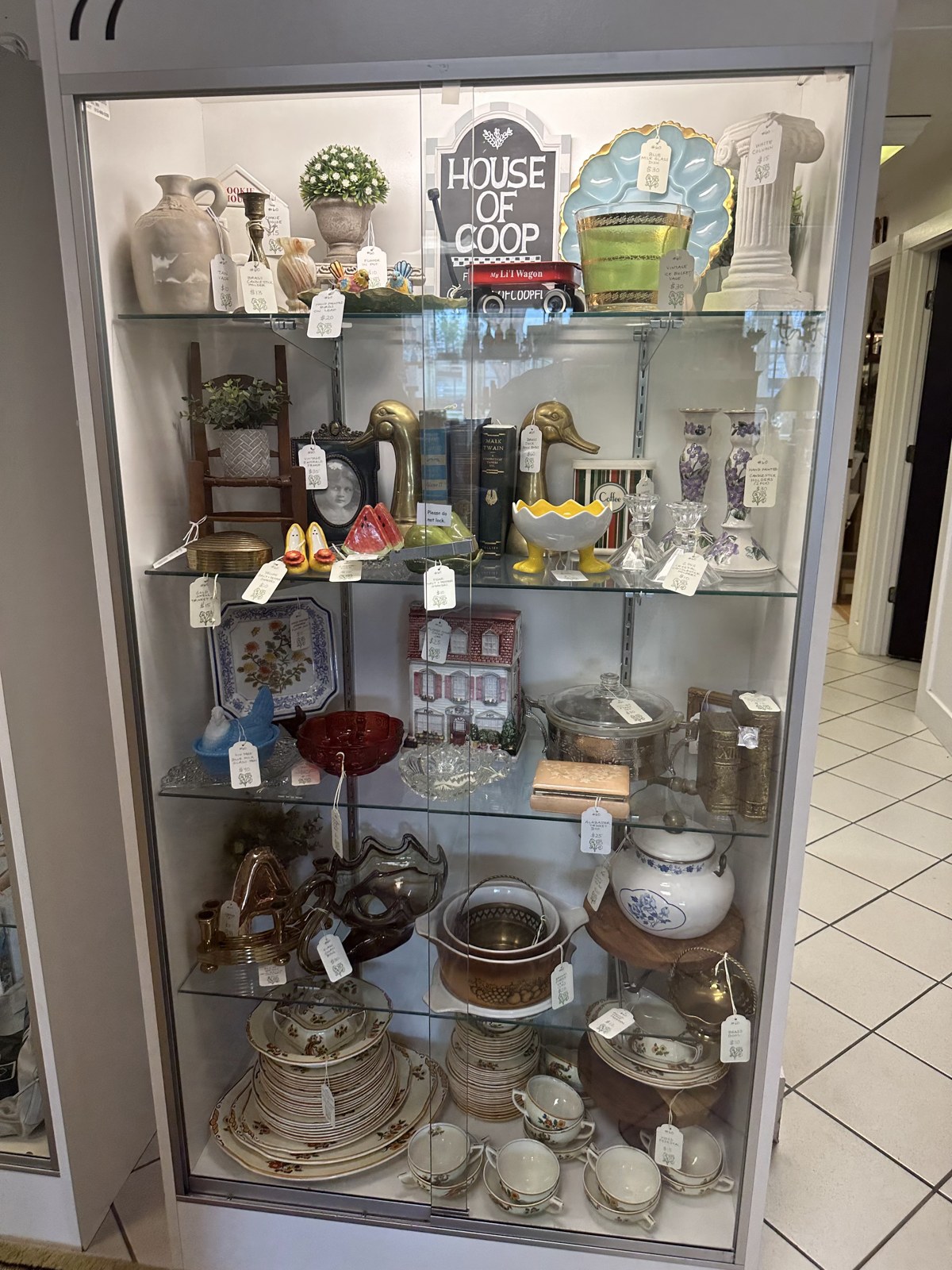House of Coop’s first antique-mall space in Palmetto, a glass cabinet filled with vintage pieces